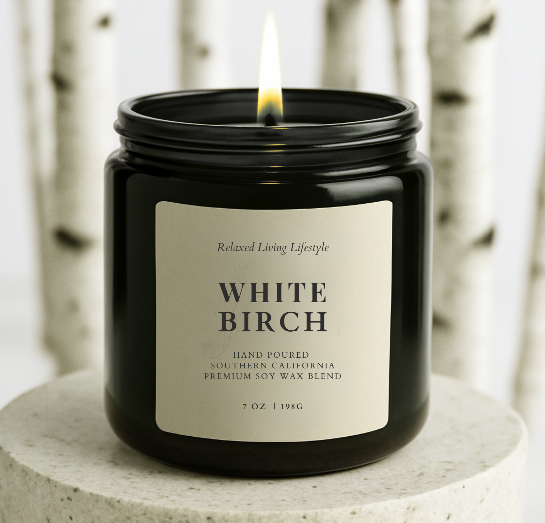 White Birch soy candle with lid off and bestseller badge, styled in front of birch trees for a fresh, woodsy look