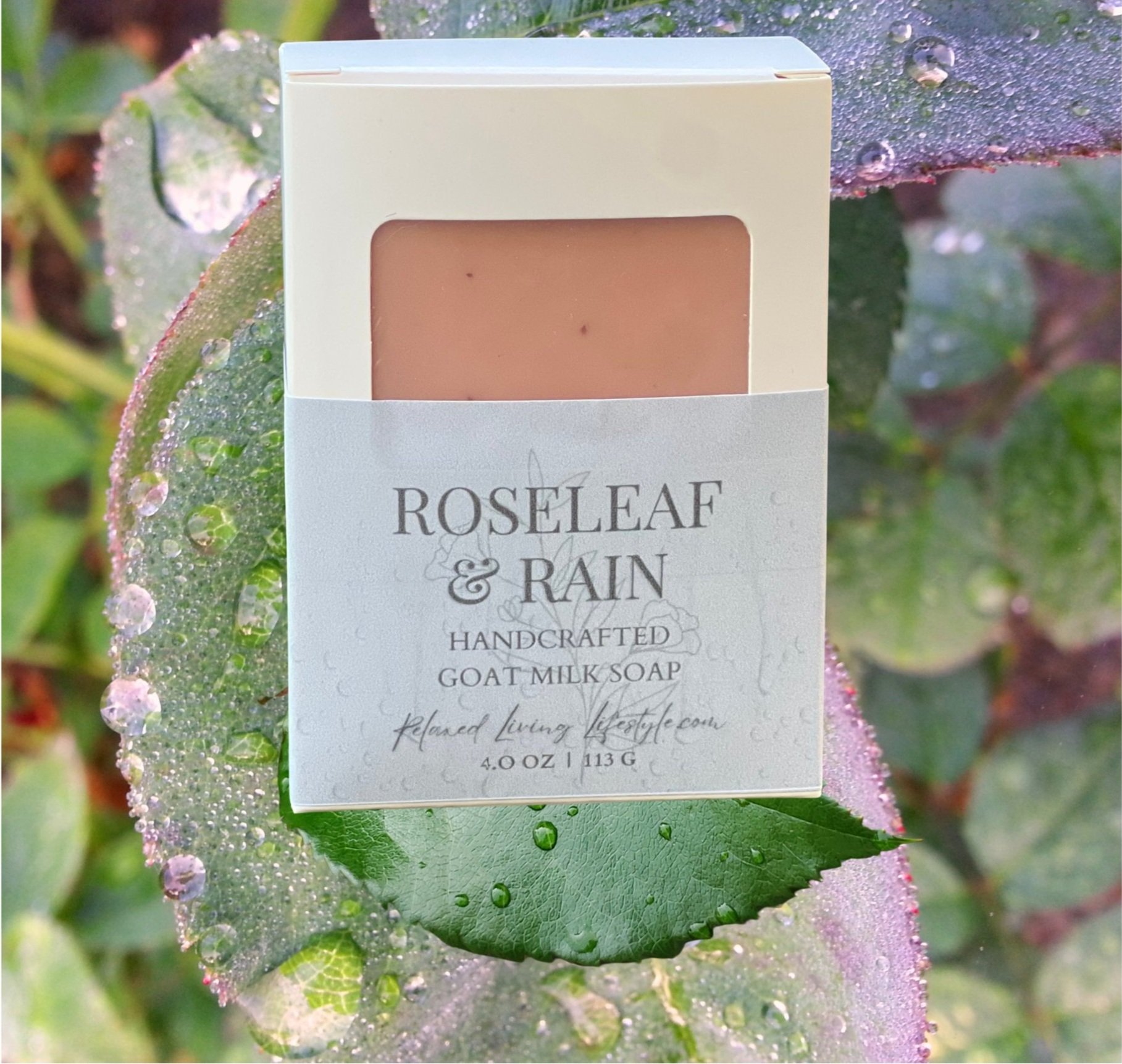 Roseleaf & Rain goat milk soap in labeled window box, styled with rose leaves and raindrops-floral artisan soap