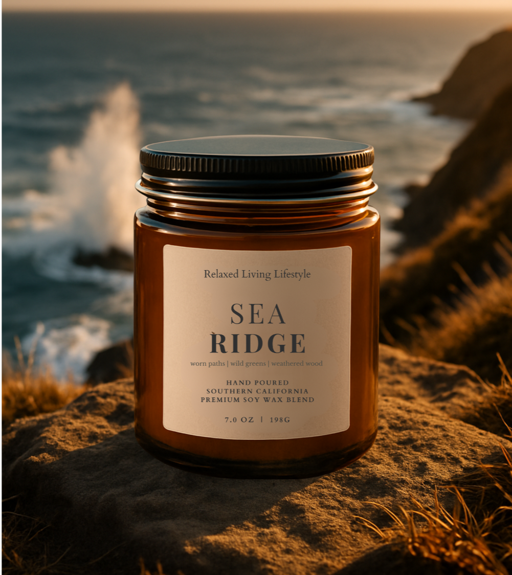 Sea Ridge soy wax blend candle with lid on, styled on a sea ridge overlooking the coastline
