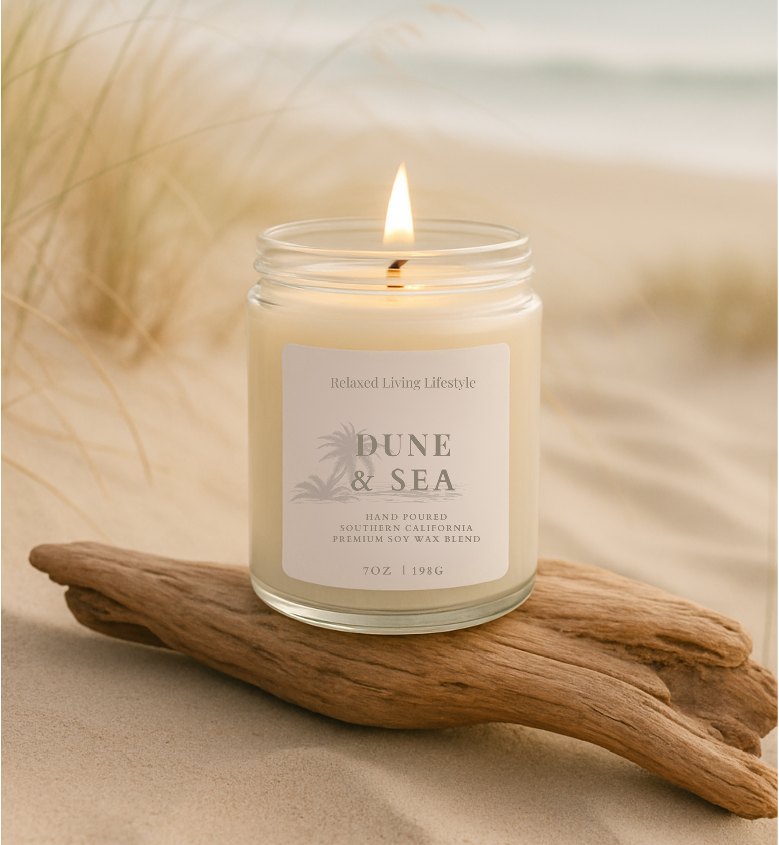 Lit dune & Sea candle on driftwood, coastal scene with ocean background and wispy grasses
