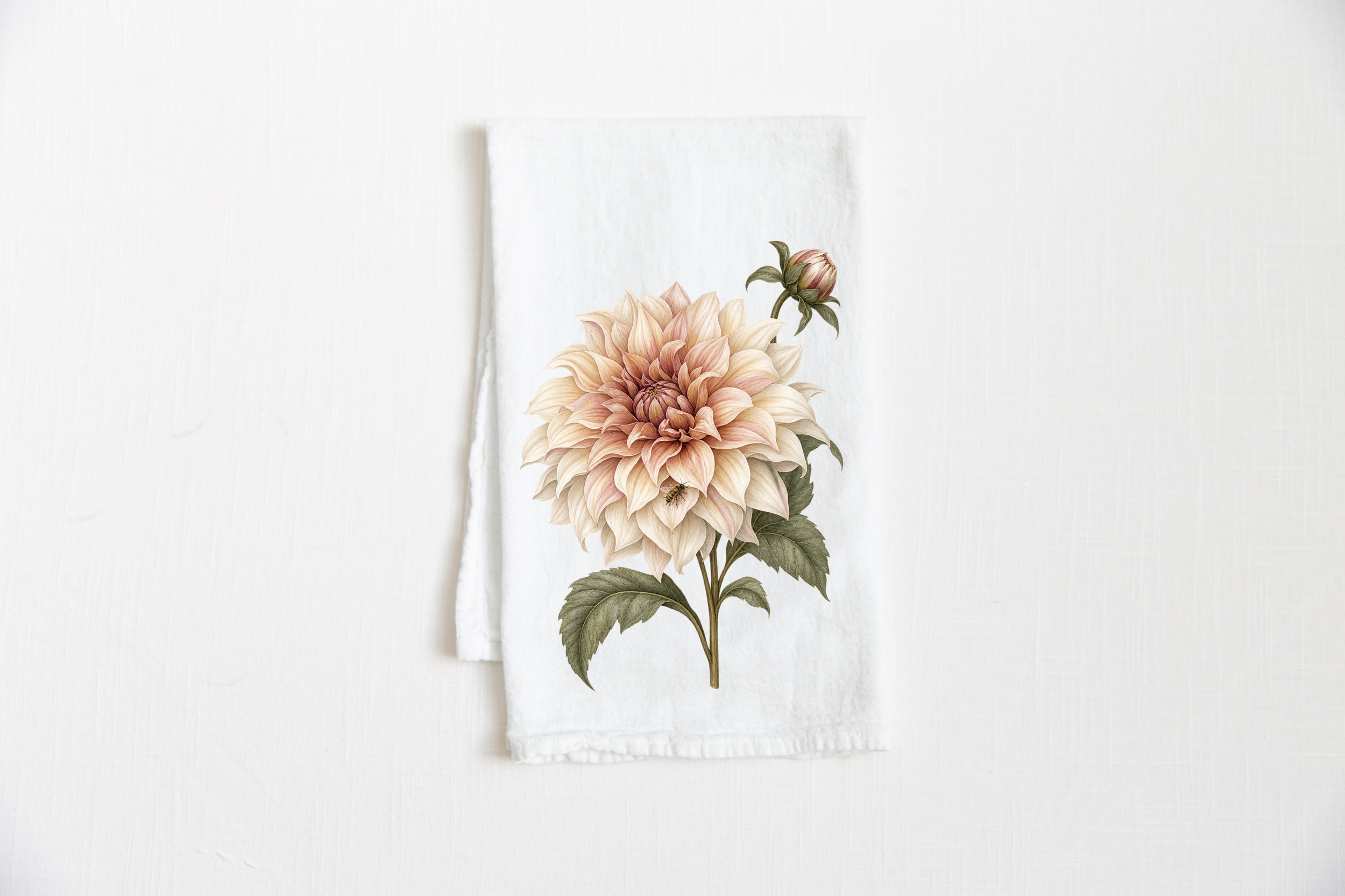Dahlia Tea Towel featuring a large cream and blush botanical dahlia with muted green leaves and a small bee on a white tea towel