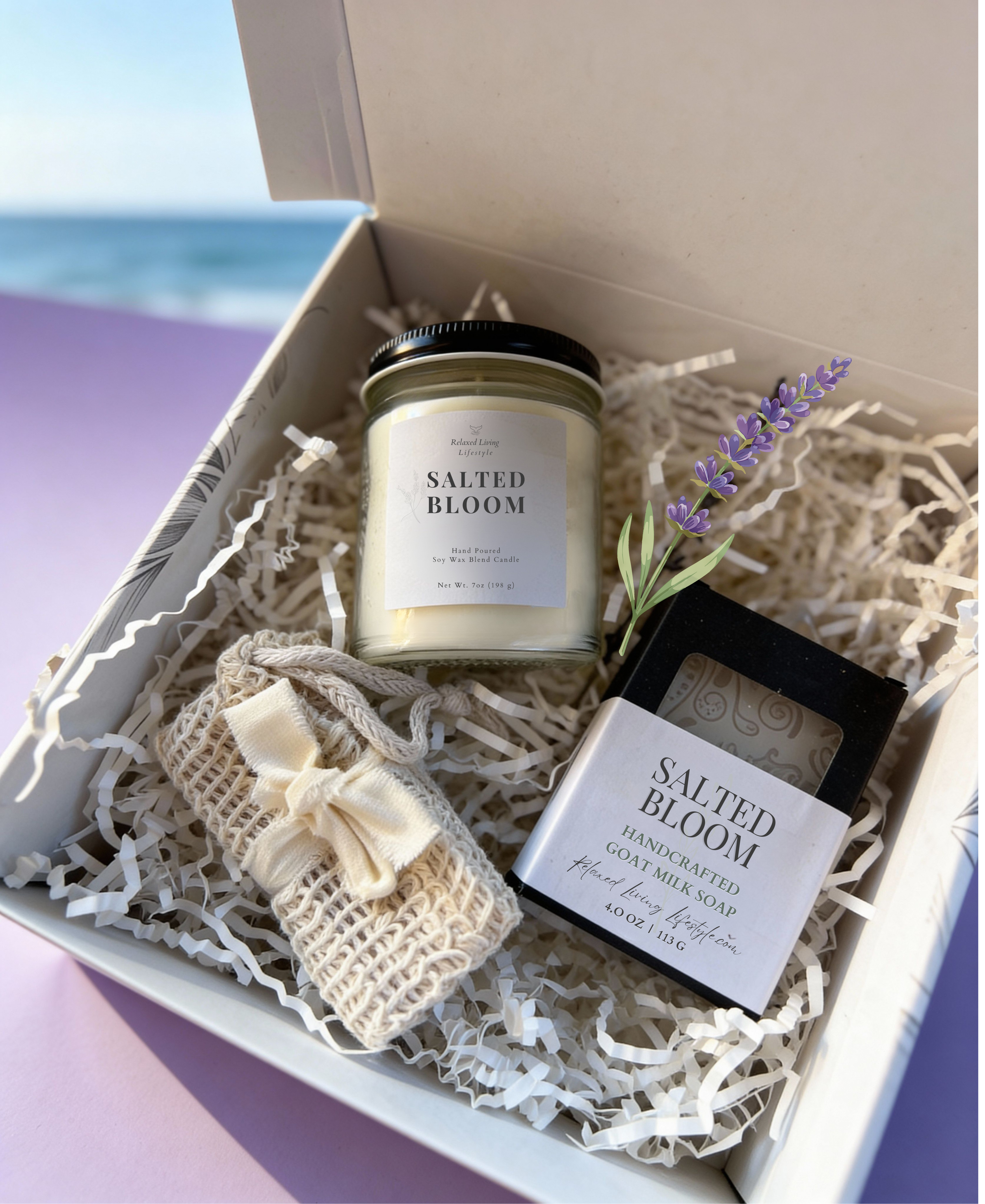 Salted Bloom candle and soap gift set displayed in a curated gift box with a soft ocean view in the distance, creating a coastal home fragrance setting