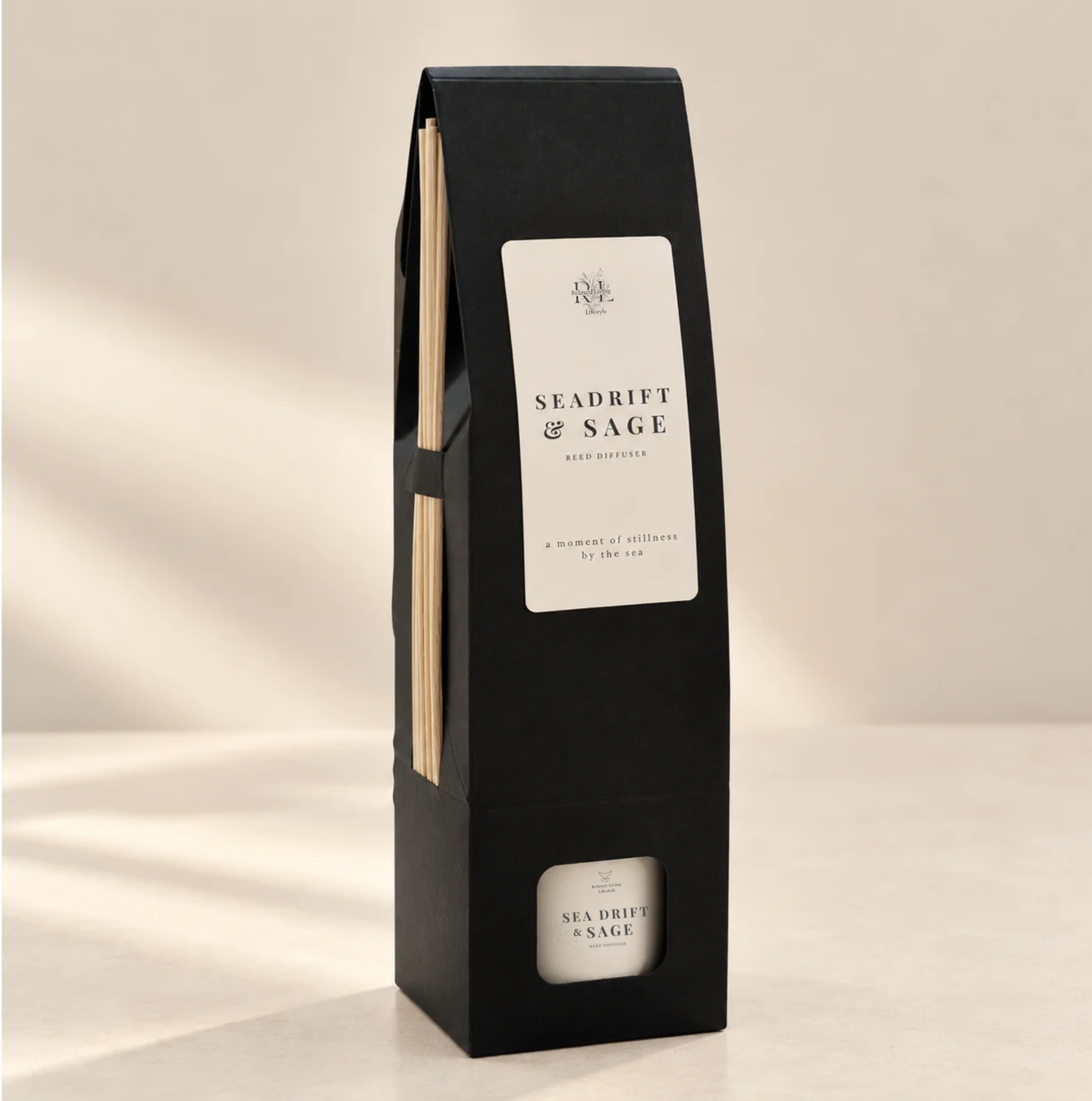Sea Drift & Sage reed diffuser in a black gift box with natural reeds, white fragrance label, and warm ivory background.