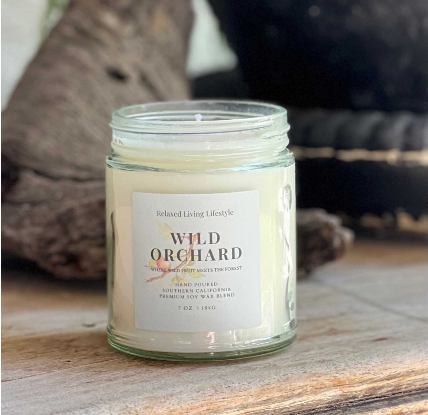Wild Orchard candle with notes of pear, apple, green leaves, and vanilla in a natural setting