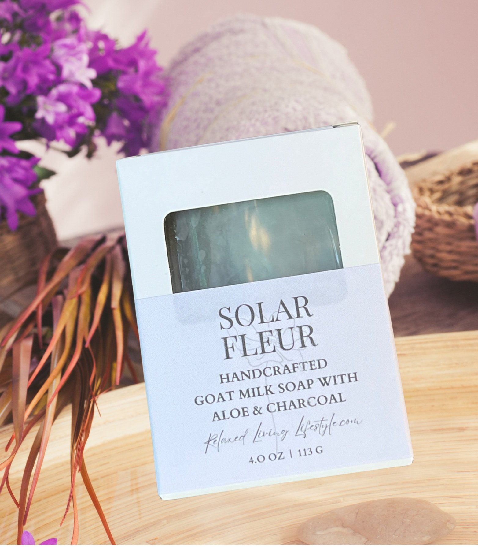 4 oz Solar Fleur soap bar with detoxifying charcoal and soothing aloe, styled on a floral background