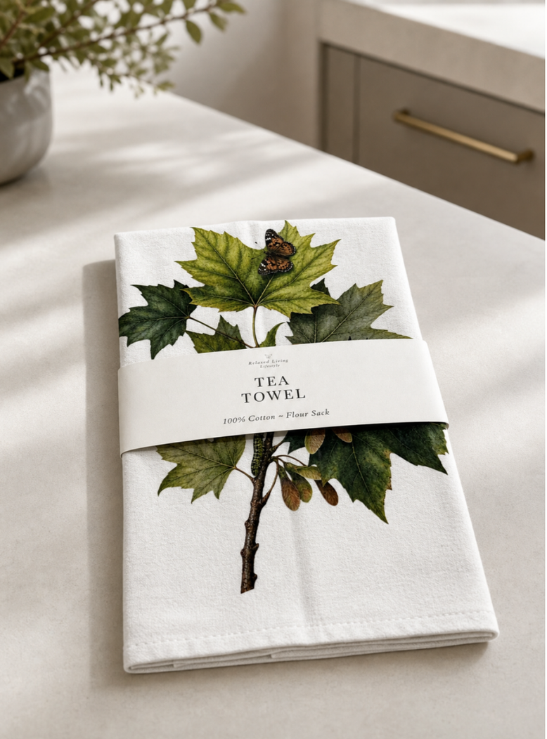 Botanical maple leaf print cotton tea towel with butterfly detail, banded label, styled in a bright light kitchen