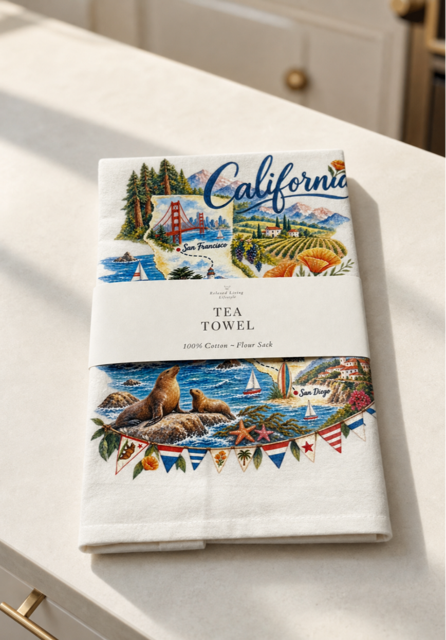 California map print cotton tea towel with coastal illustrations, banded label, styled in a bright luxury kitchen