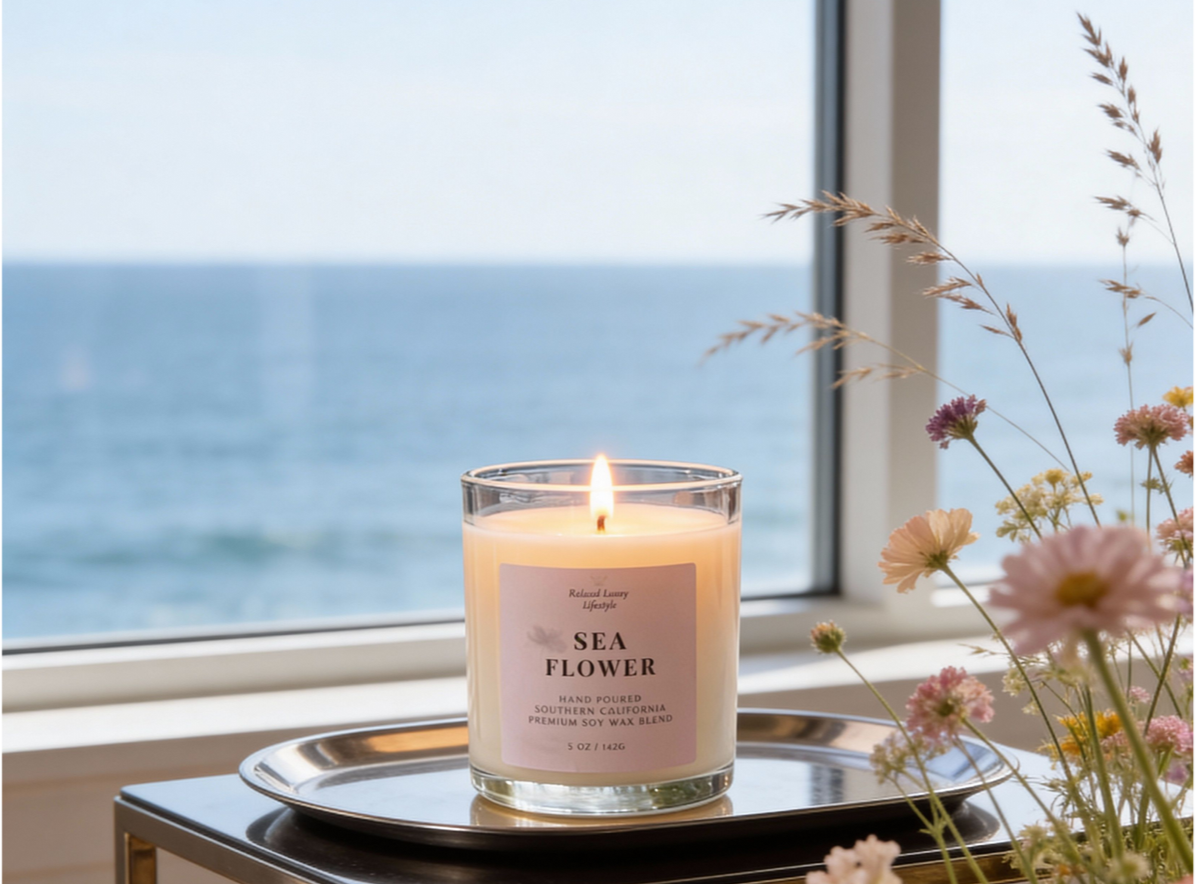 Sea Flower 5 oz soy candle on tray with ocean view and wildflowers. Coastal floral scented candle with jasmine, honeydew, sandalwood, and marine notes.