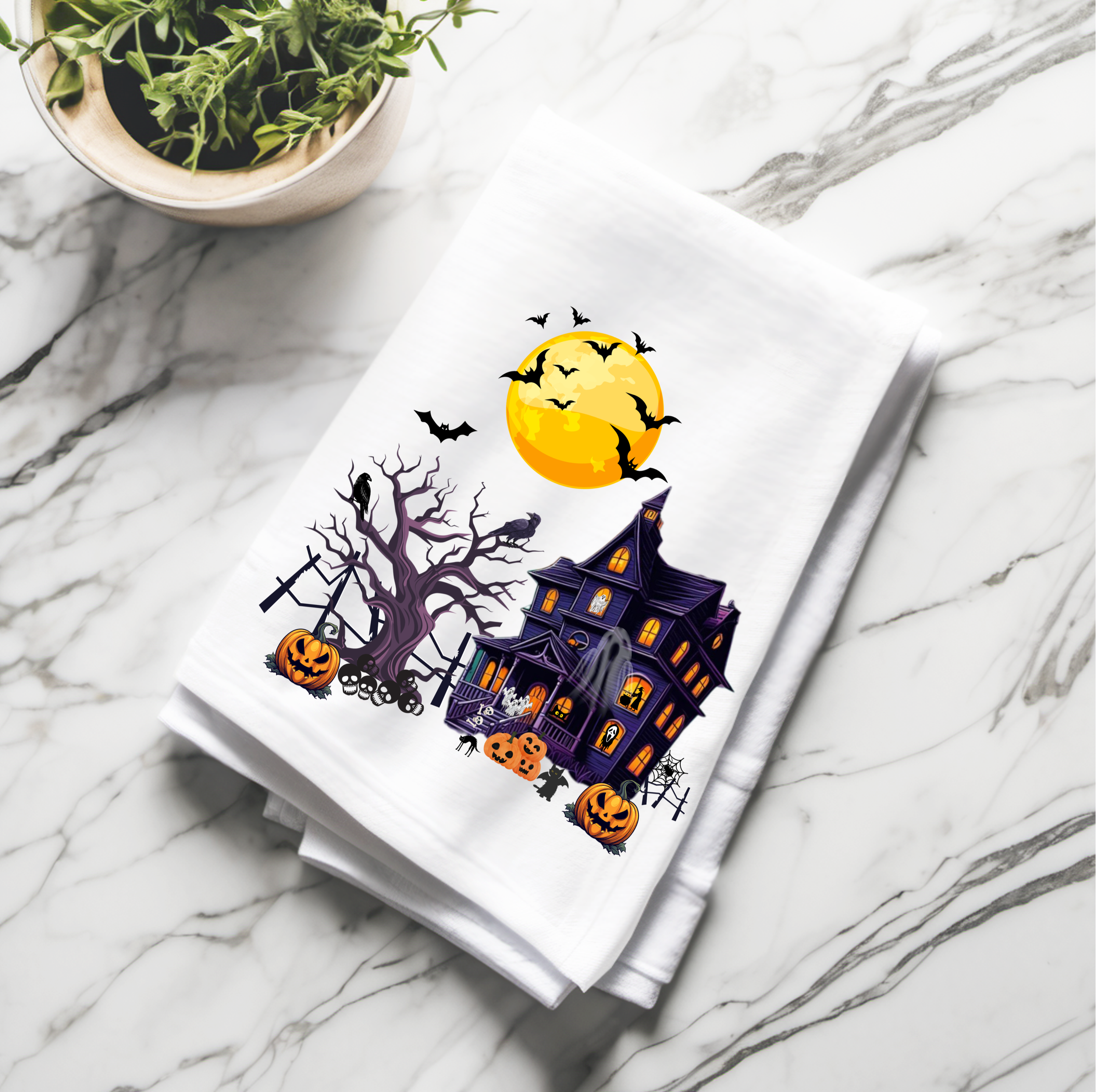 Halloween cotton tea towel with haunted house design, perfect for fall kitchen decor and seasonal gifting