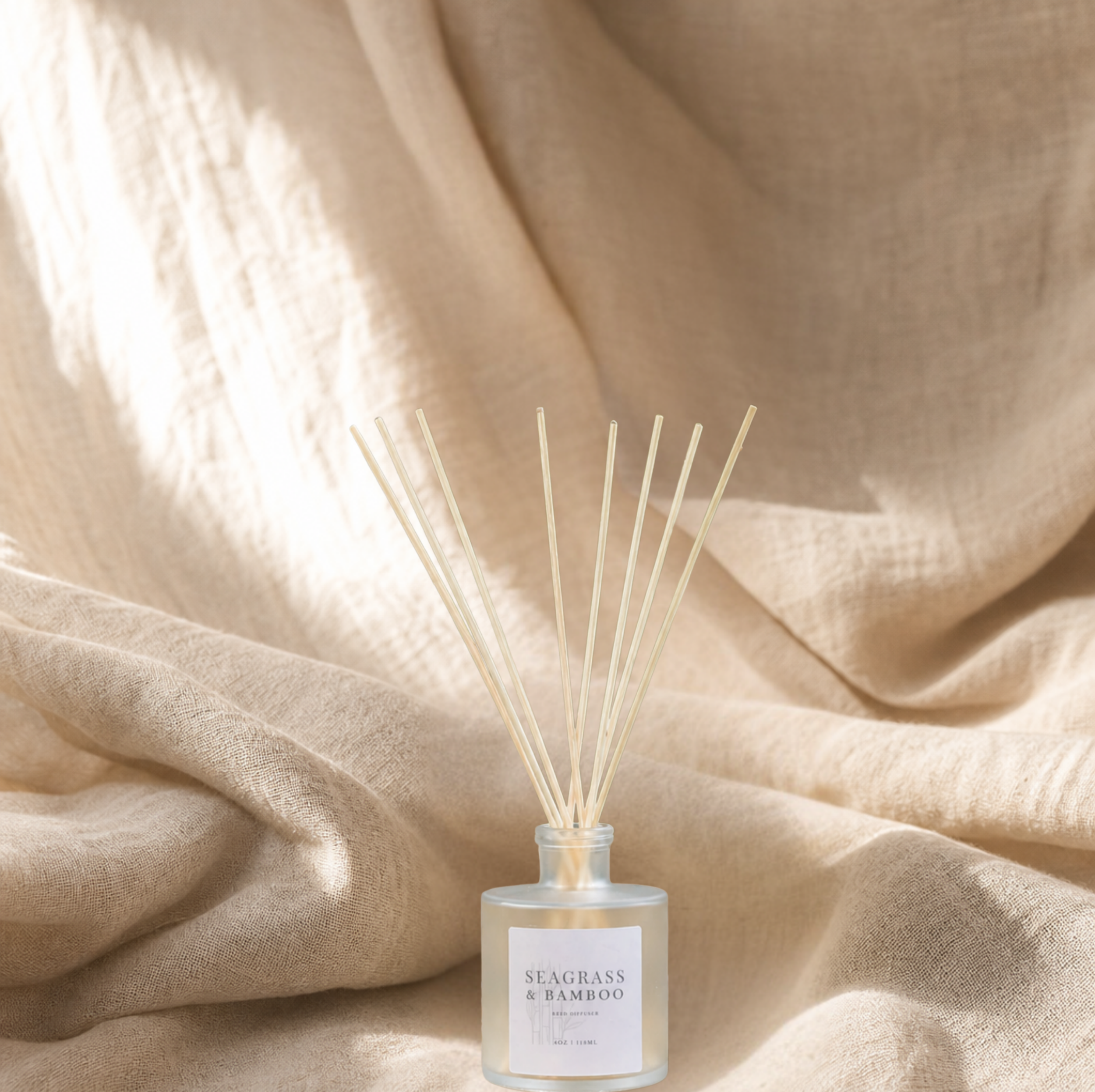 Seagrass & Bamboo 4oz reed diffuser in a frosted glass bottle with natural reeds on soft neutral linen