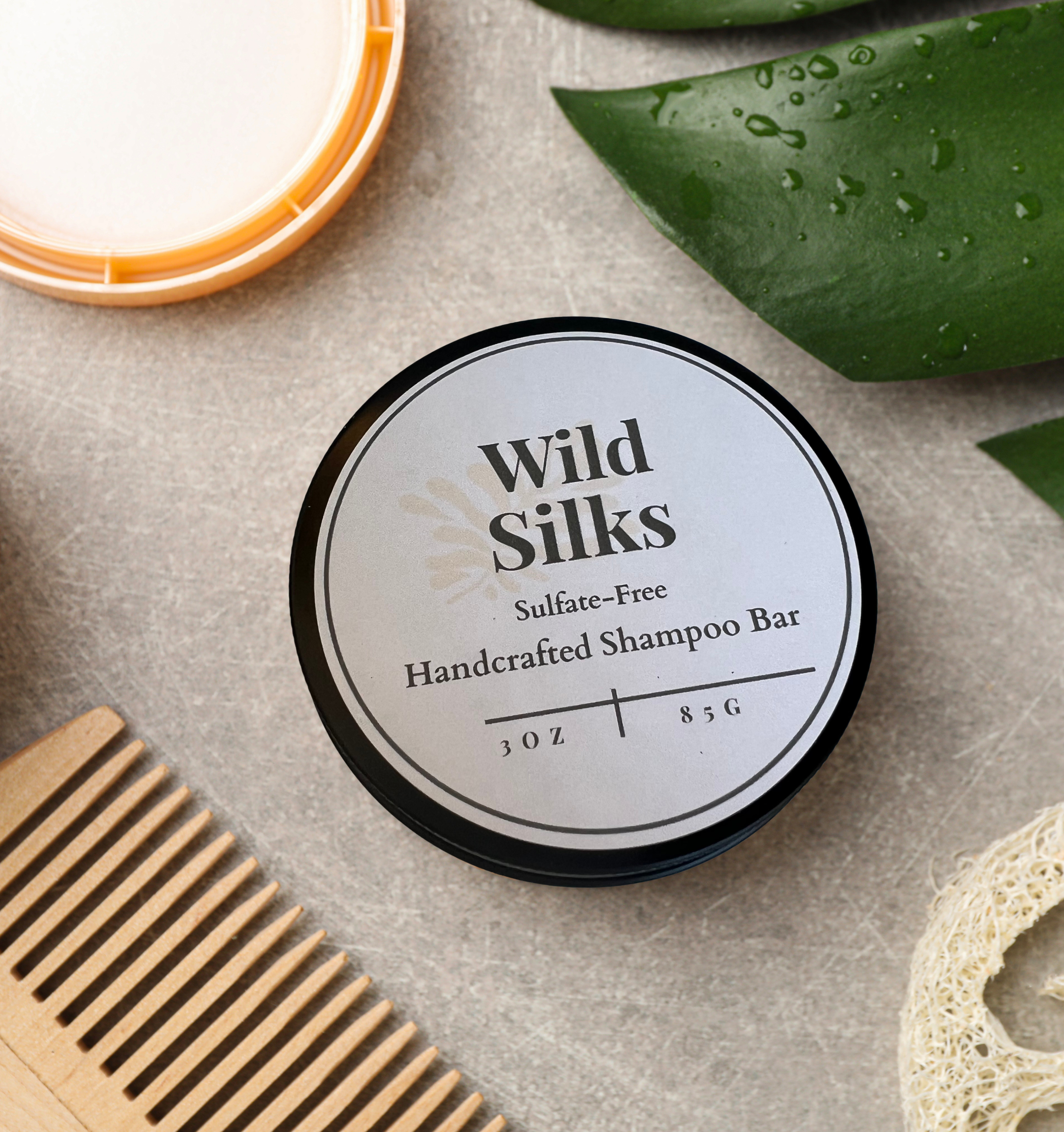 Wild Silks shampoo bar surrounded by citrus elements, featuring a bright essential oil blend with lemons, orange and grapefruit notes