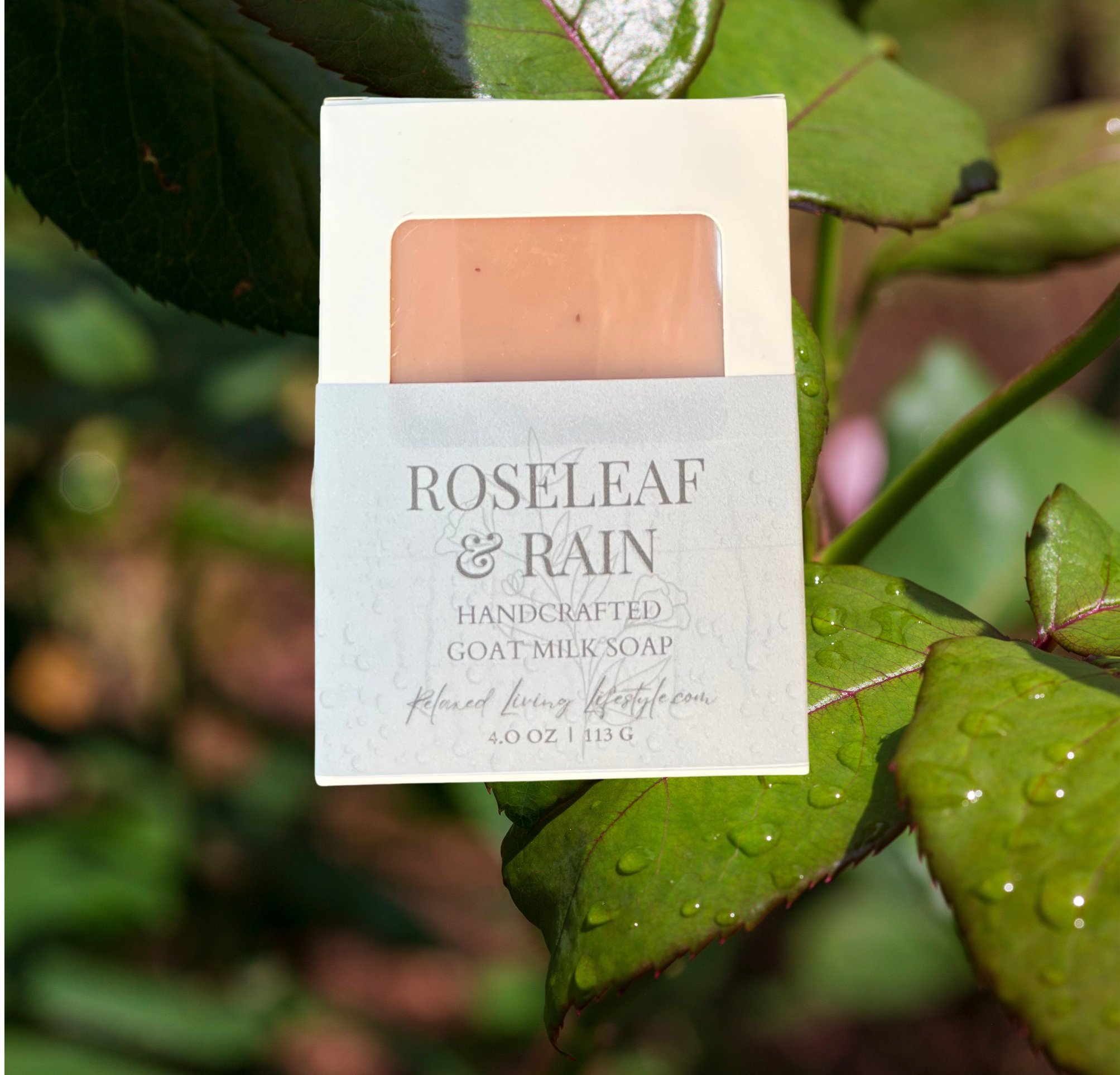 Boxed Roseleaf & Rain soap with visible label, displayed among fresh rose leaves and water droplets