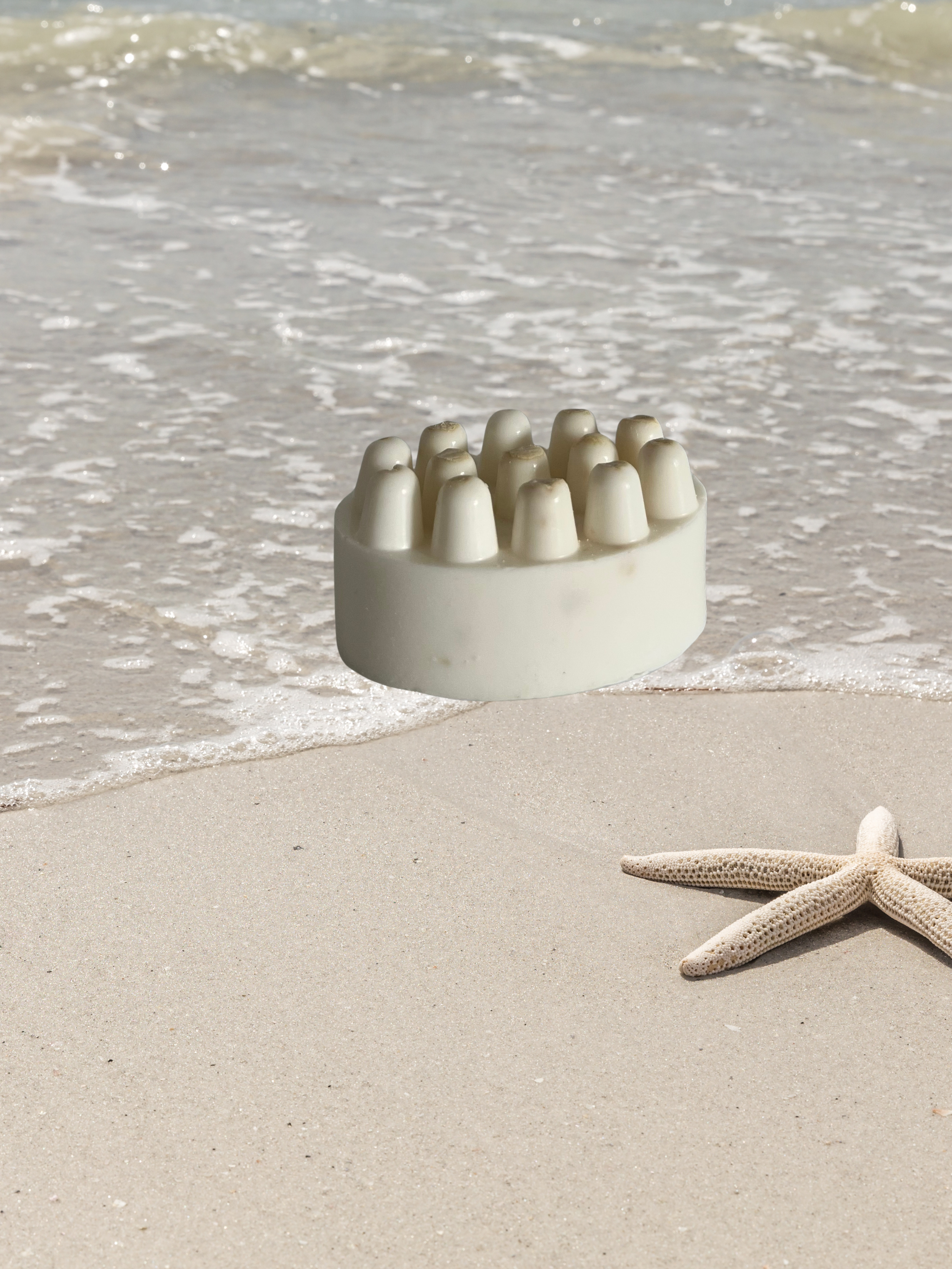 Unwrapped Seaside Retreat shea butter massage bar with textured surface, styled on sand-like-setting to evoke beach atmosphere-artisan coastal soap