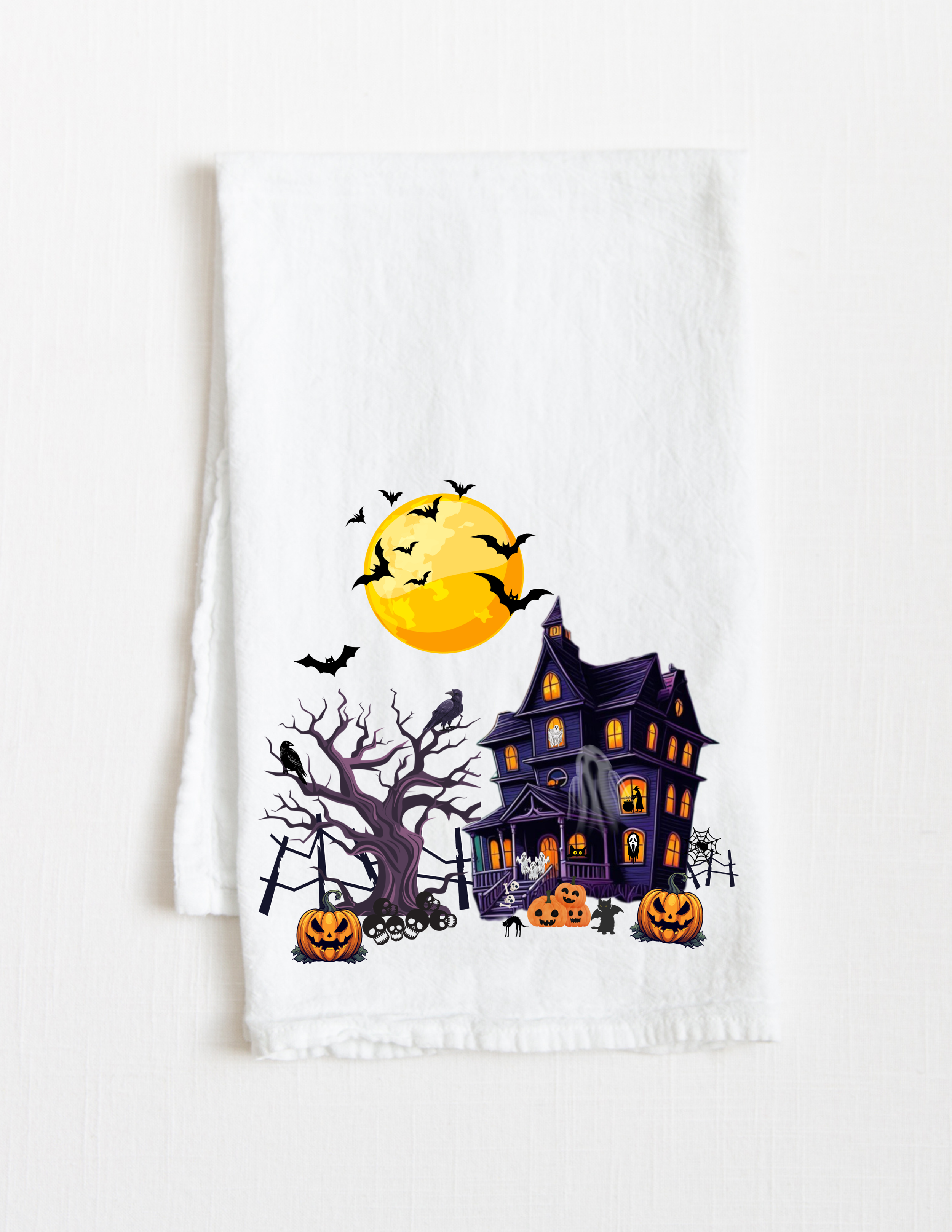 Halloween cotton tea towel with haunted house design, perfect for fall kitchen decor and seasonal gifting