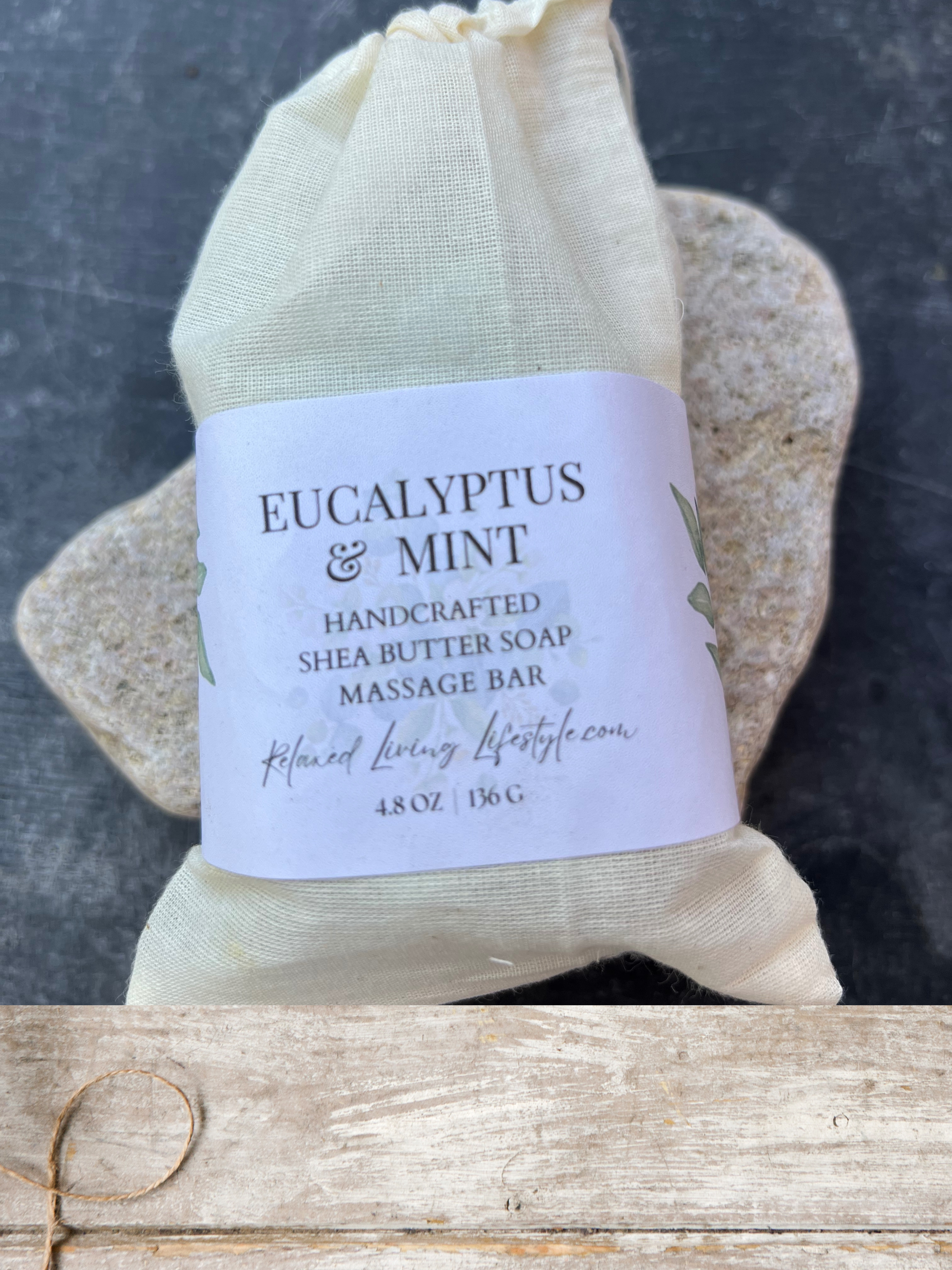 Flat lay of eucalyptus & mint shea butter massage bar wrapped in pure cotton cheesecloth bag-artisan soap for a refreshing spa-like experience