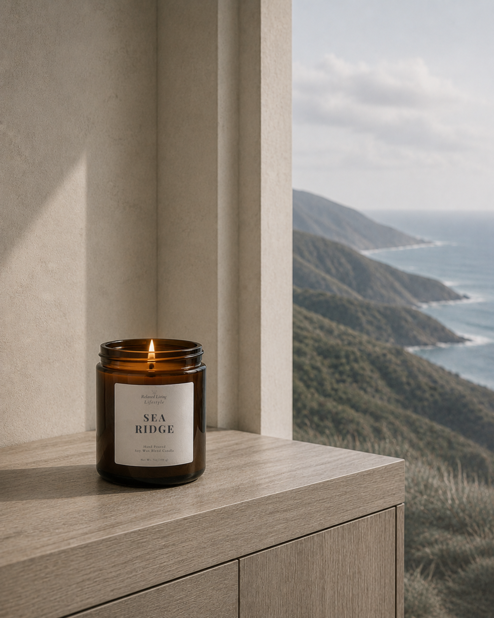 “Lit Sea Ridge soy wax blend candle in an amber glass jar styled in a light-filled coastal-inspired interior with natural textures and a softly blurred background.”