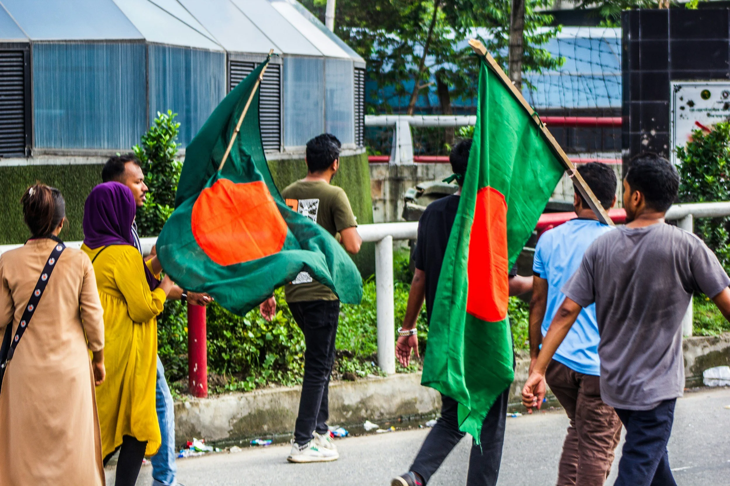 Young Bangladeshis carrying national flags during a public gathering in Bangladesh.