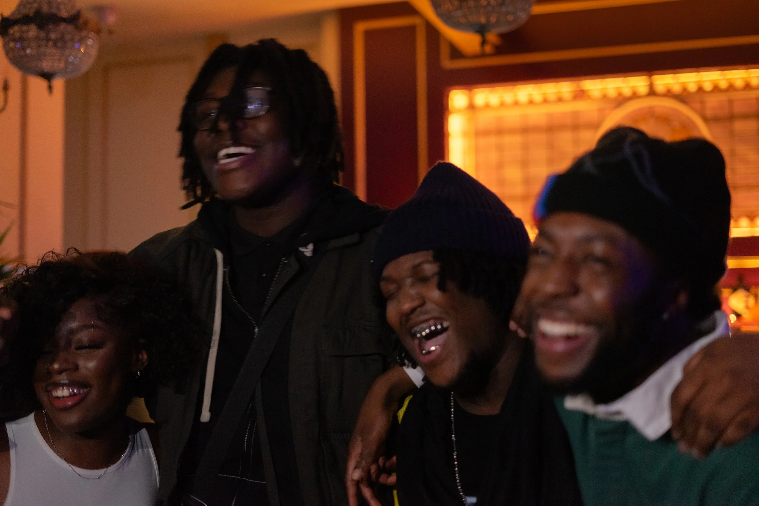 Group of four friends laughing and having fun indoors