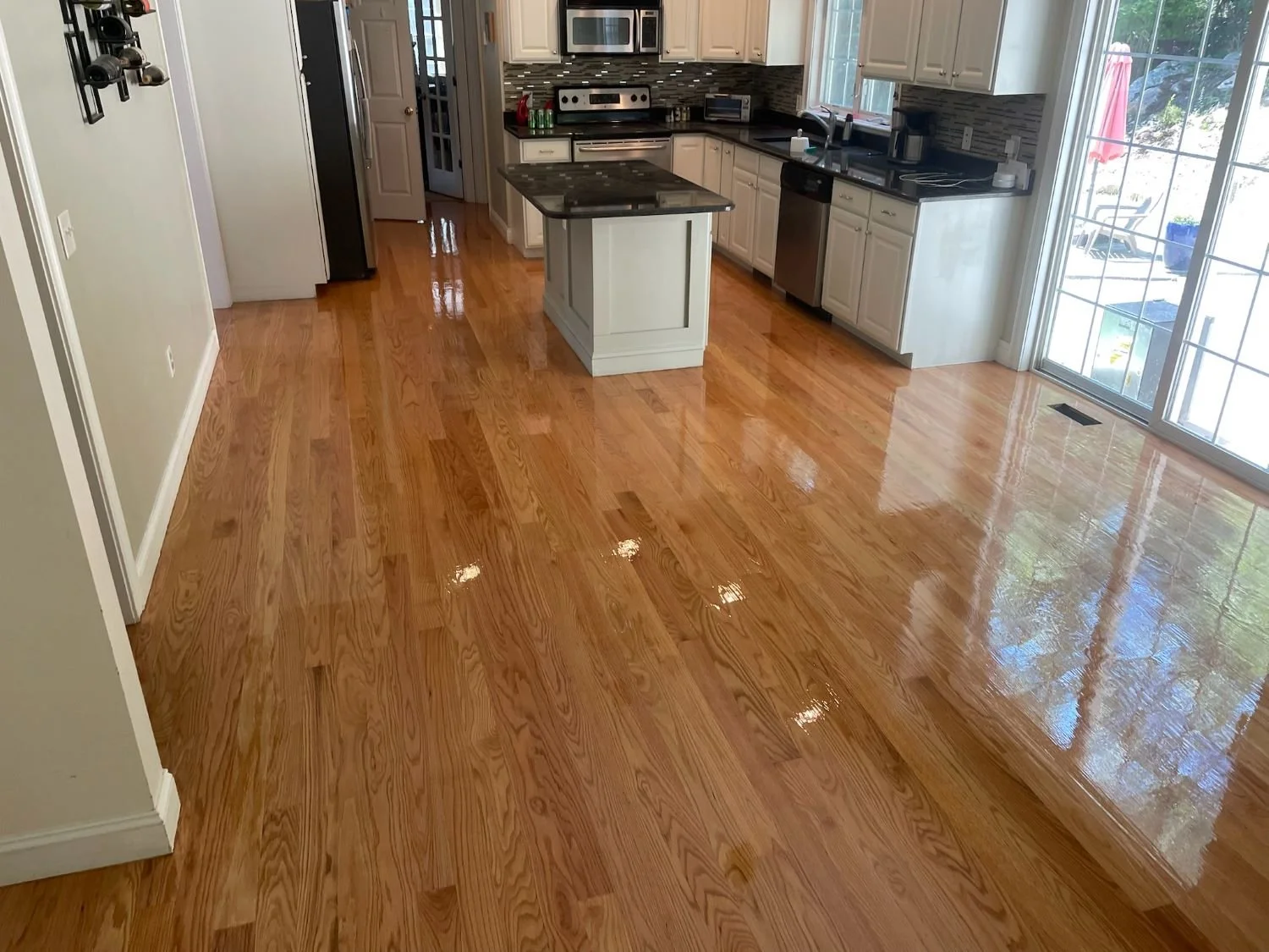 kitchen with shiny hardwood floors that are reflecting the light form sliding doors