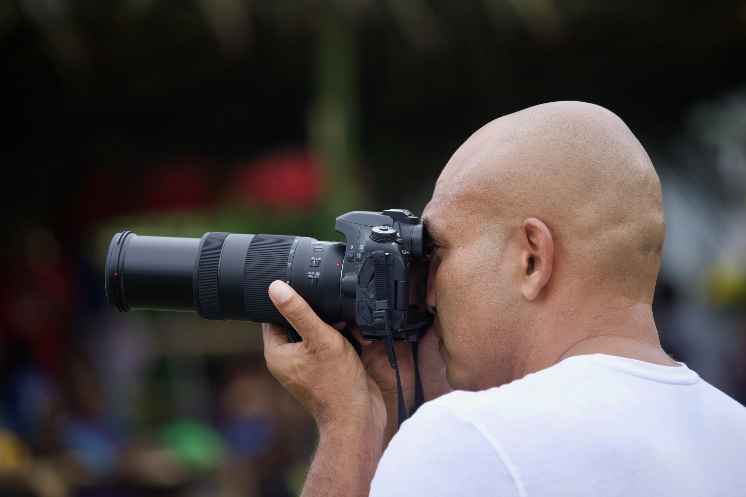 Photographer with a telephoto lens capturing a scene in Papua New Guinea, showcasing the immersive and hands-on experience offered on local photography tours.