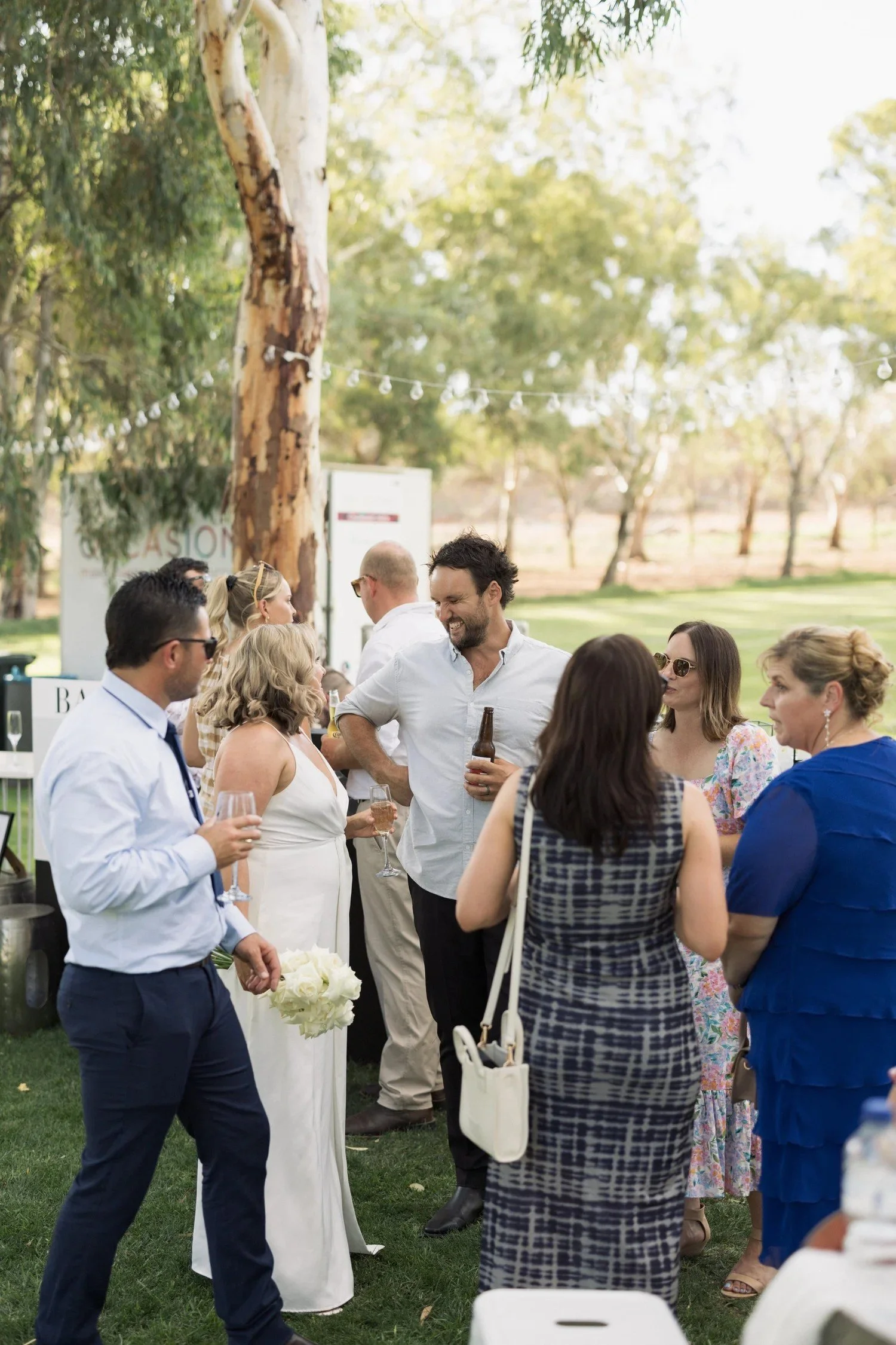 Wedding guests celebrating under festoon lights and established trees at Greenfield Acres Wedding Venue, Riverland SA