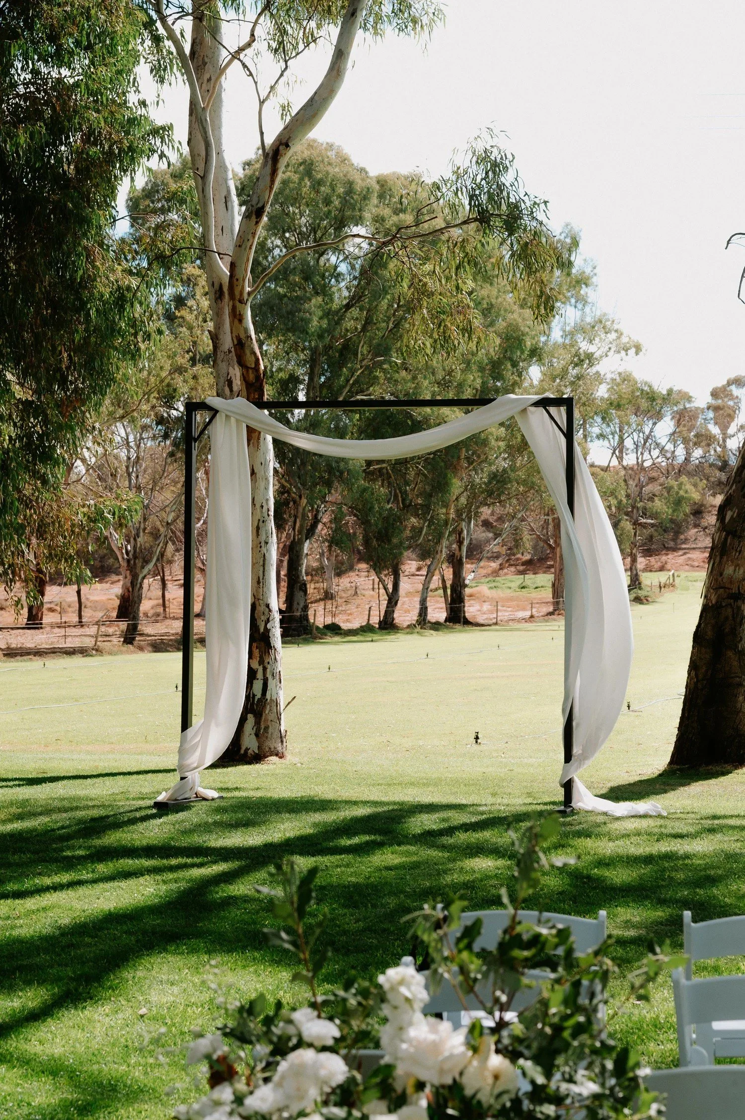 White draped wedding arbour set on the manicured lawns at Greenfield Acres Wedding Venue, Riverland SA