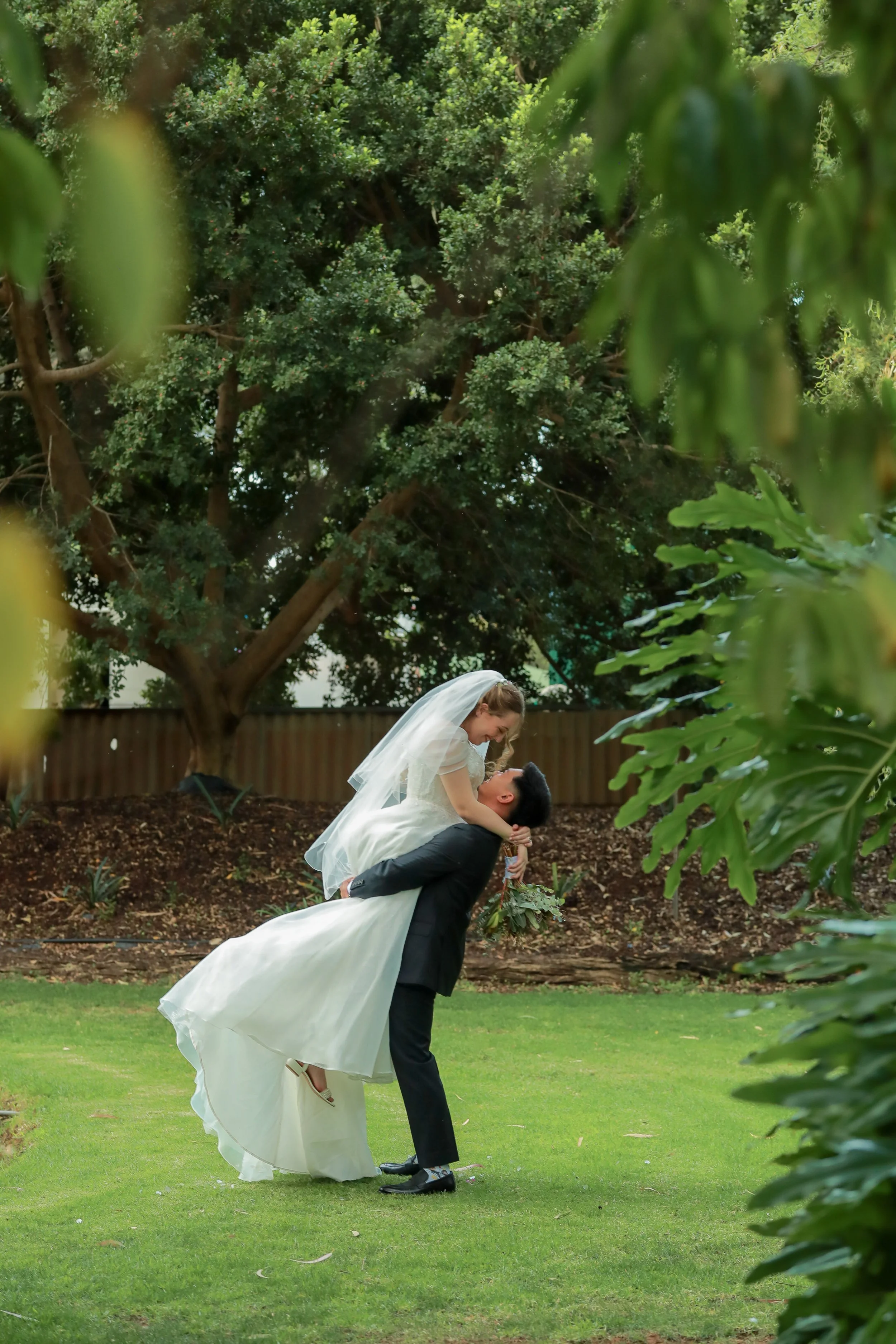 Bride and groom sharing a joyful first dance surrounded by the gardens at Greenfield Acres Wedding Venue, a romantic outdoor wedding venue in the Riverland, South Australia.