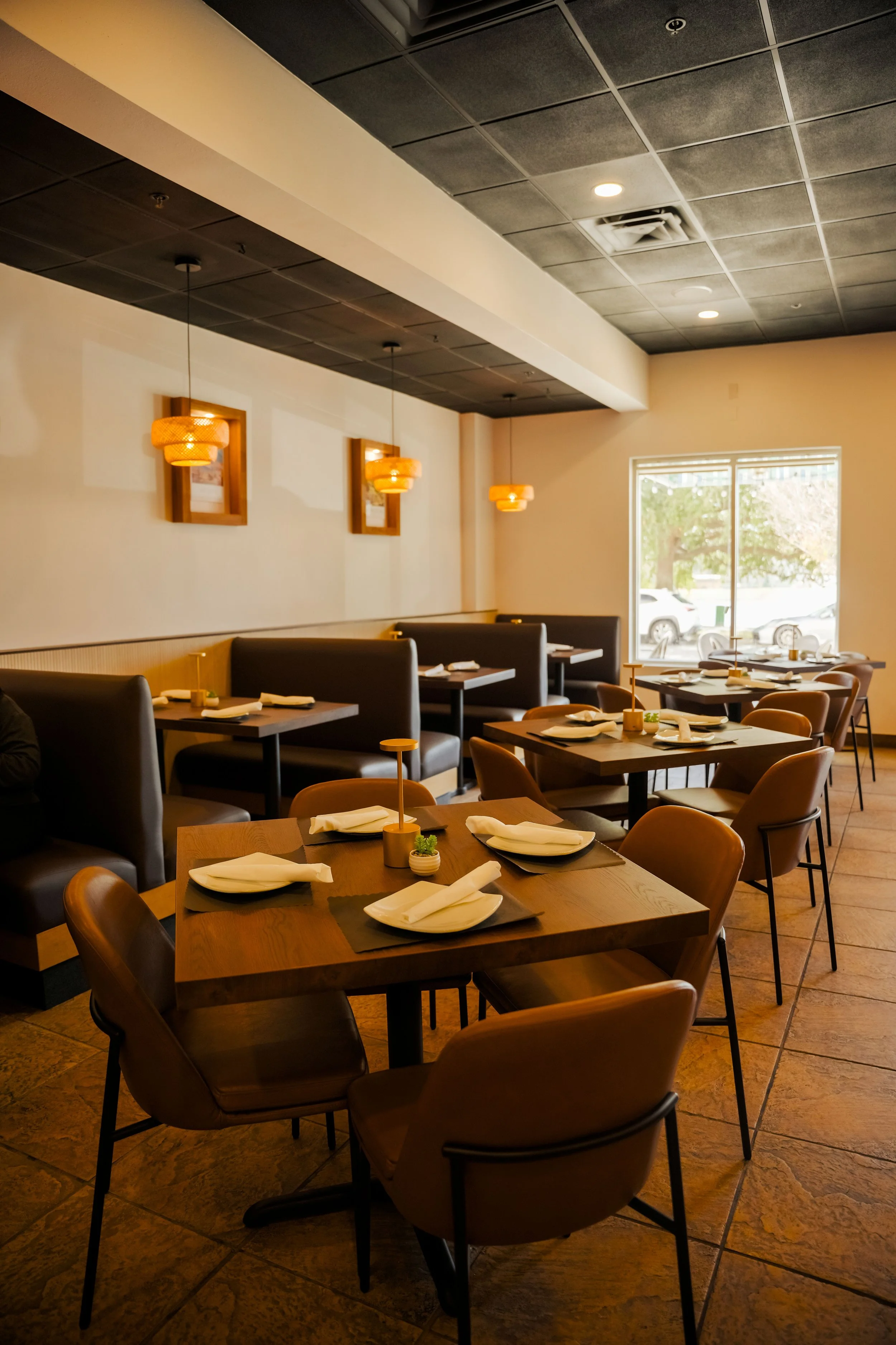 	
Interior of Chabuca Restaurant at Avalon Park. A modern restaurant with a brick wall, bar counter with highchairs, tables with chairs, and dim lighting.