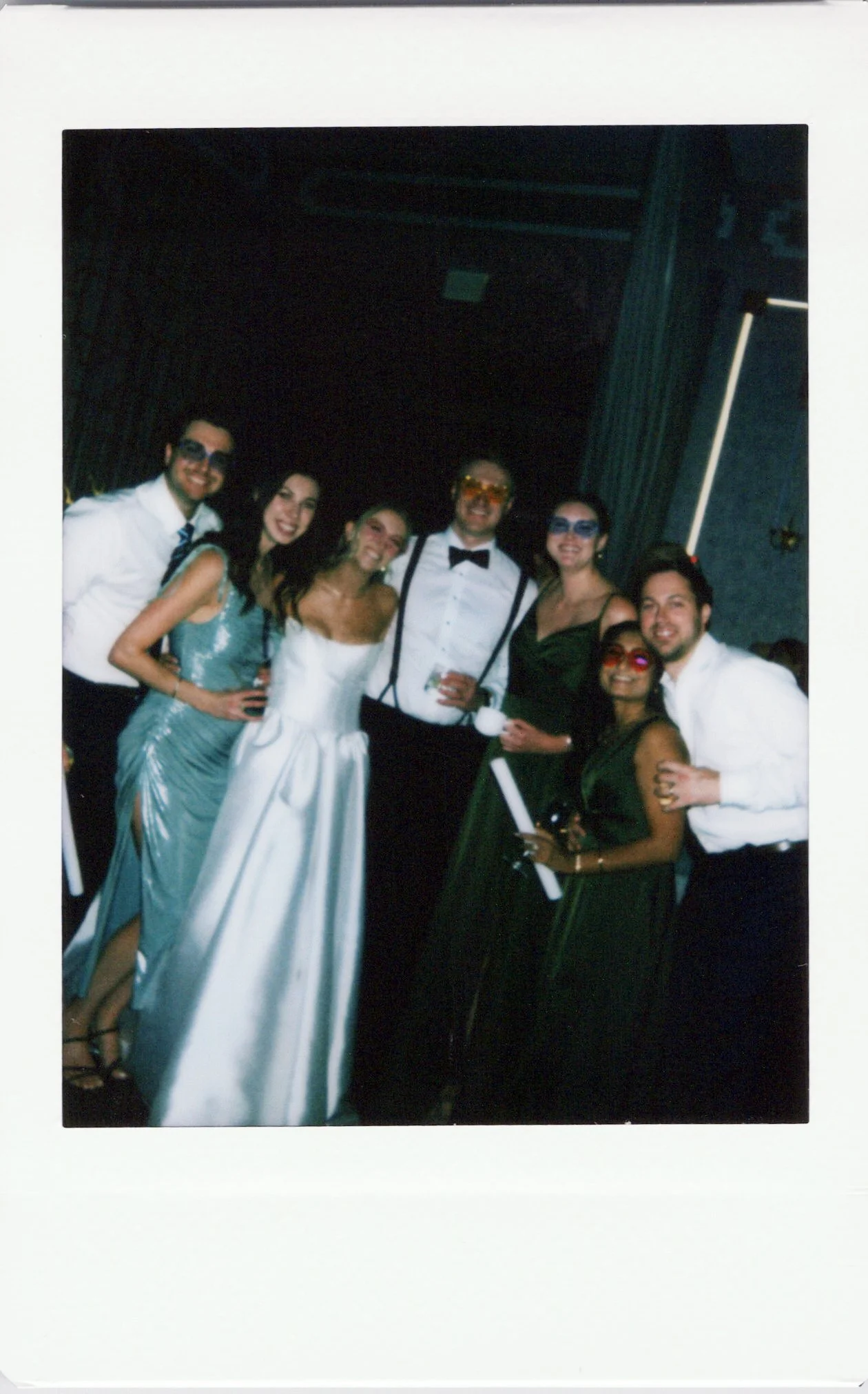 Instant photo of a group of seven people dressed in formal and semi-formal attire, smiling, at a Chicago wedding.