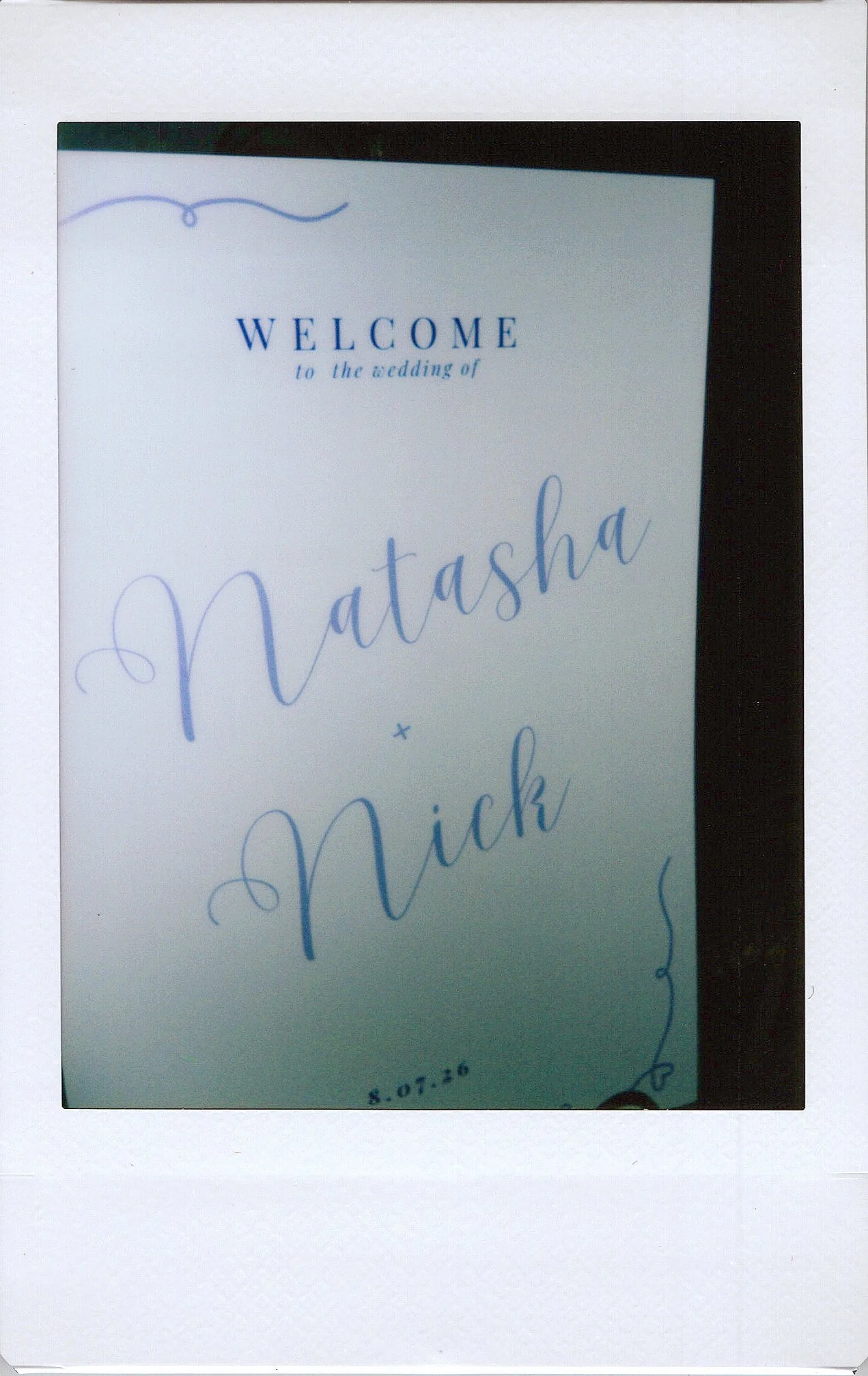 A wedding invitation with handwritten calligraphy that reads, "Welcome to the wedding of Natasha & Nick," followed by the date, 8.07.20.