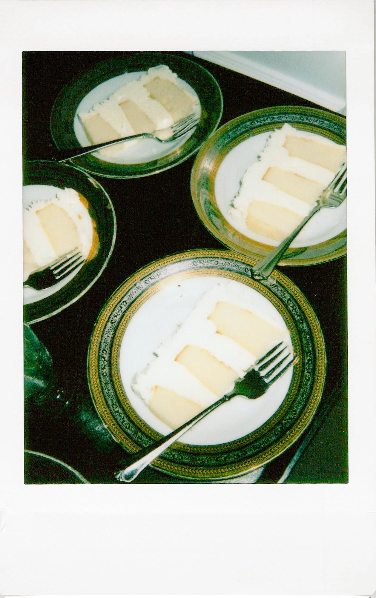 Slices of banana pudding with pudding in bowls on decorative plates, served with forks.