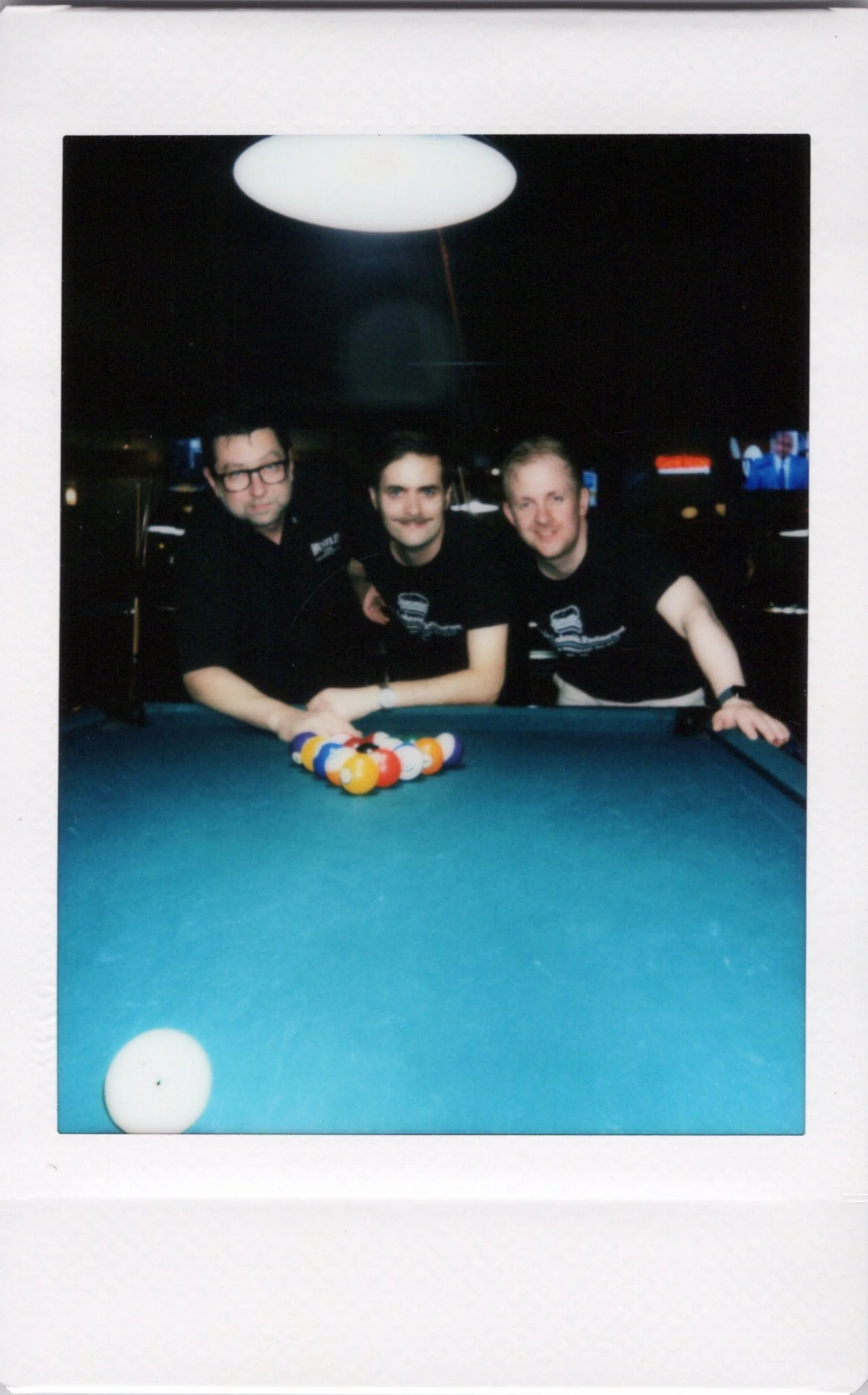 Friends posing for an onsite instant photo at a pool hall in Chicago
