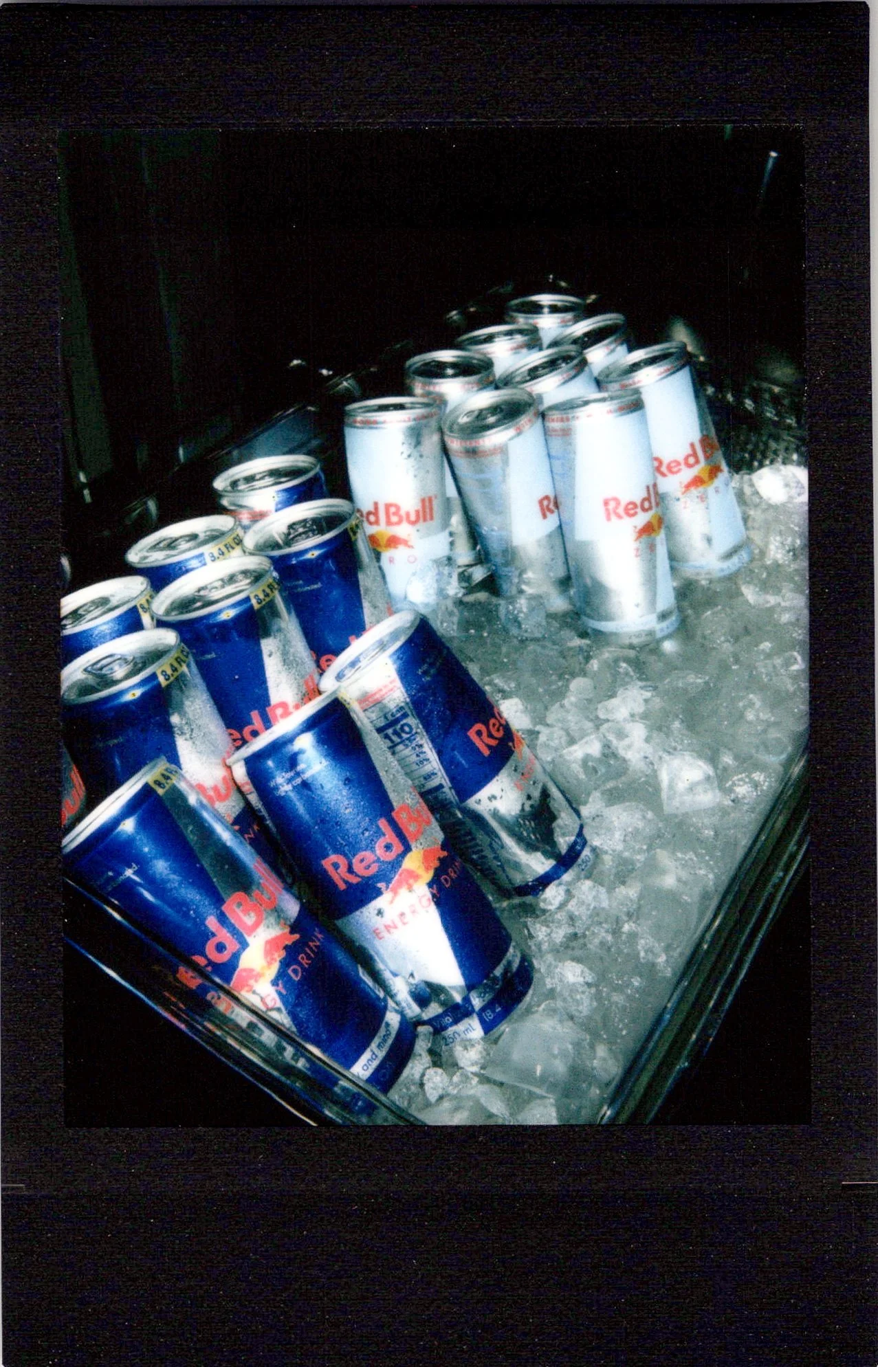 An instant photo from a brand activation for Red Bull featuring an ice box with sugar free and regular Red Bull cans