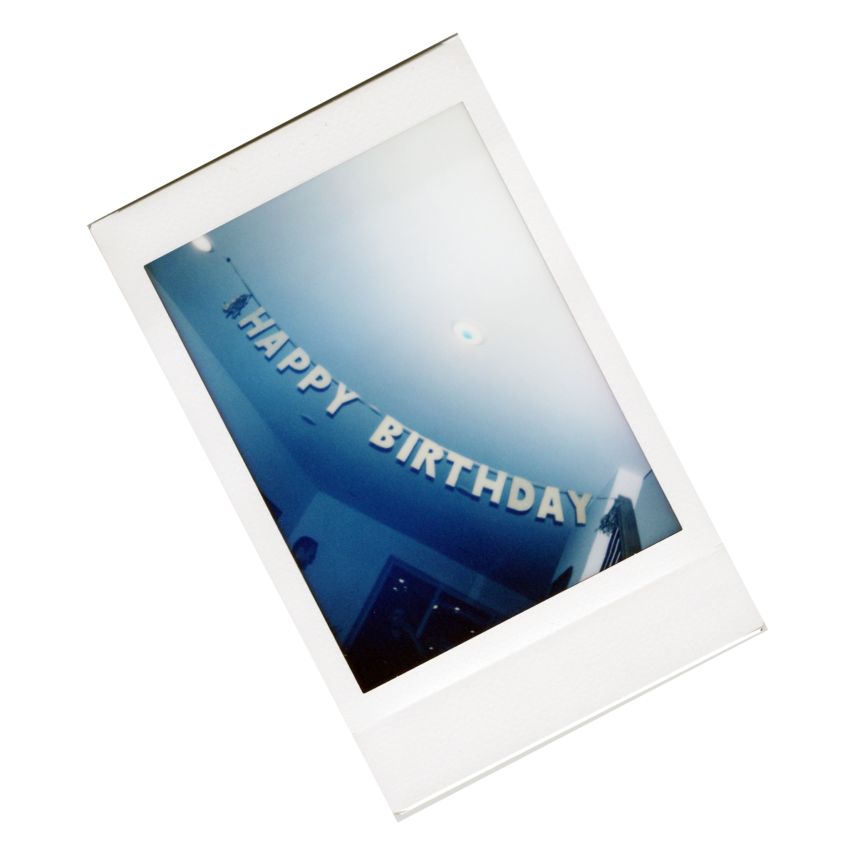 Polaroid photo of birthday banner that says 'HAPPY BIRTHDAY' hanging inside a Chicago building.