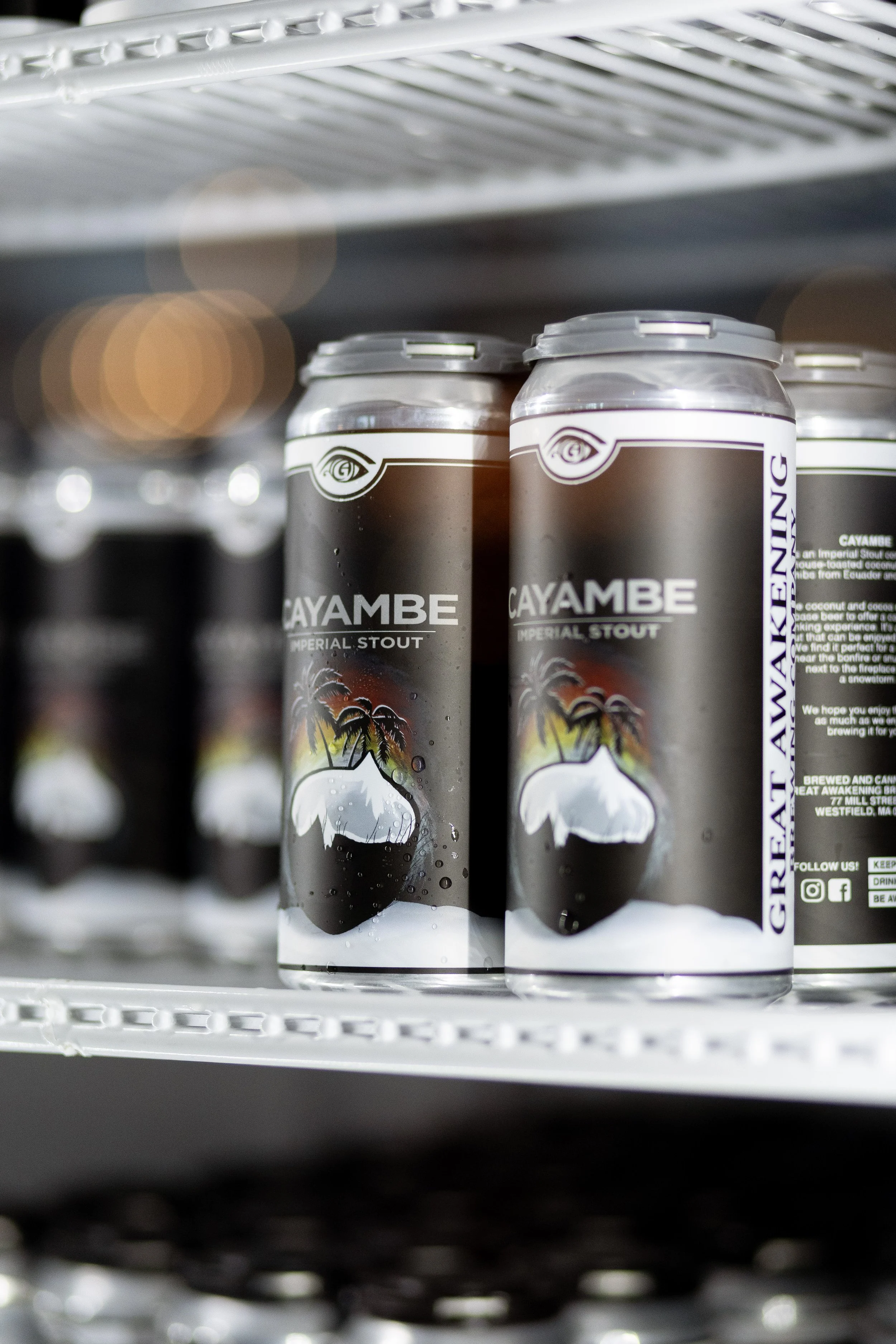 Cans of Cayambe Imperial Stout beer on a store shelf.
