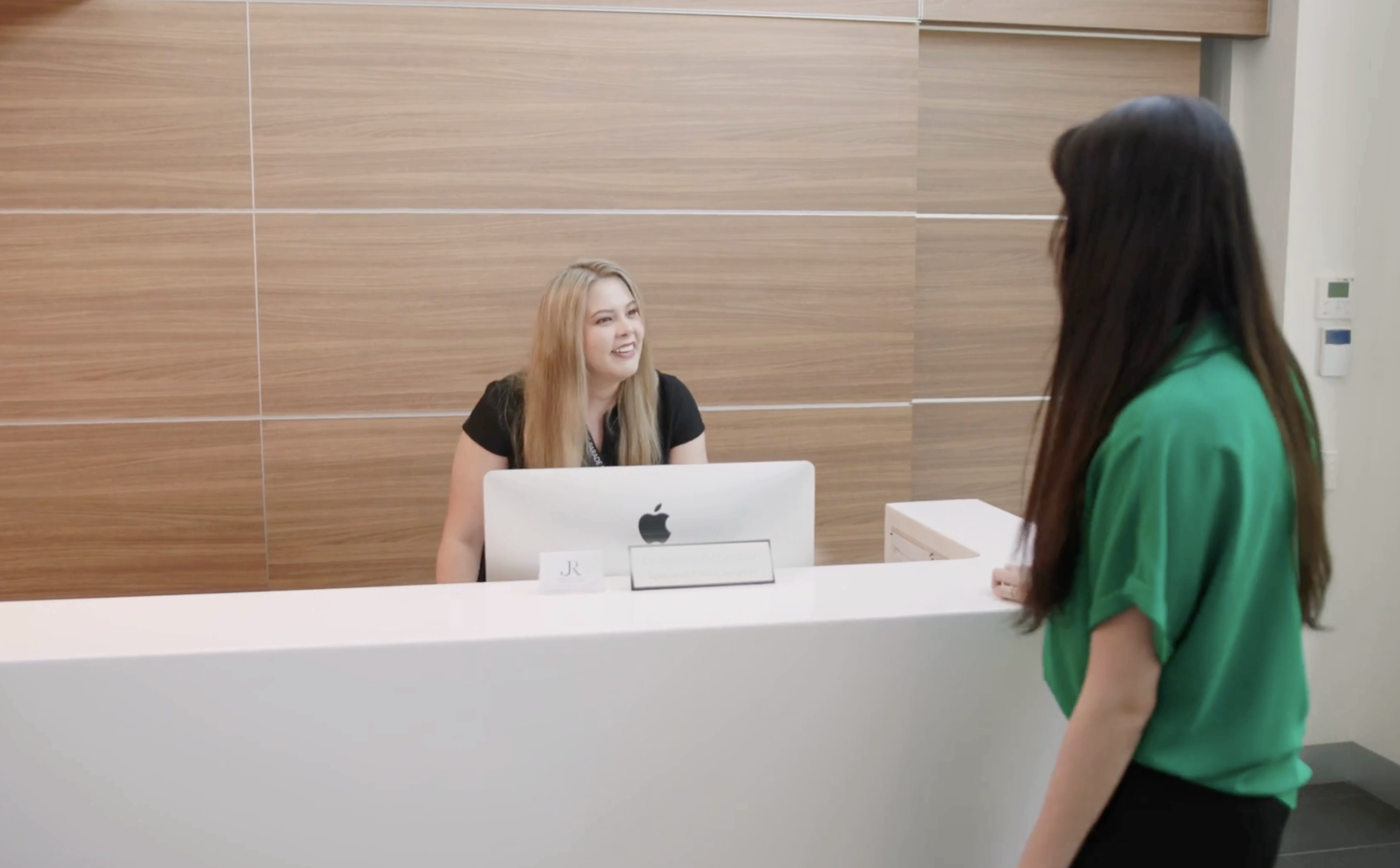 Patient approaching friendly receptionist at Dr Sophia Richardson's OMFS oral surgery practice