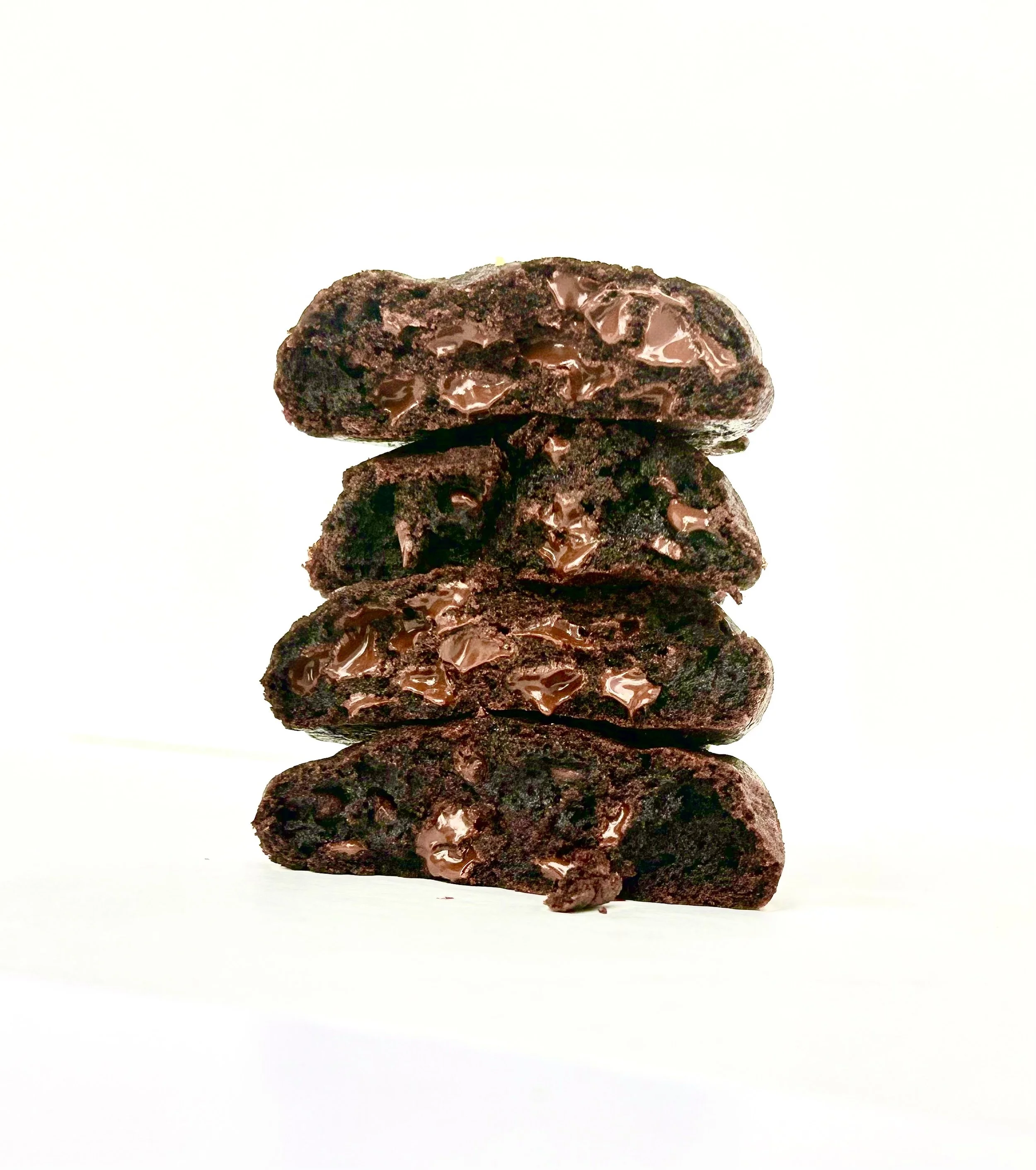 Stacked chocolate cookies with chocolate chips on a white background.