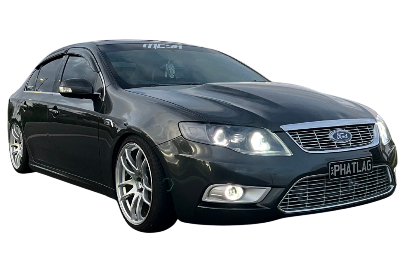 Black Ford sedan with aftermarket wheels and license plate reading 'PHATLAG'