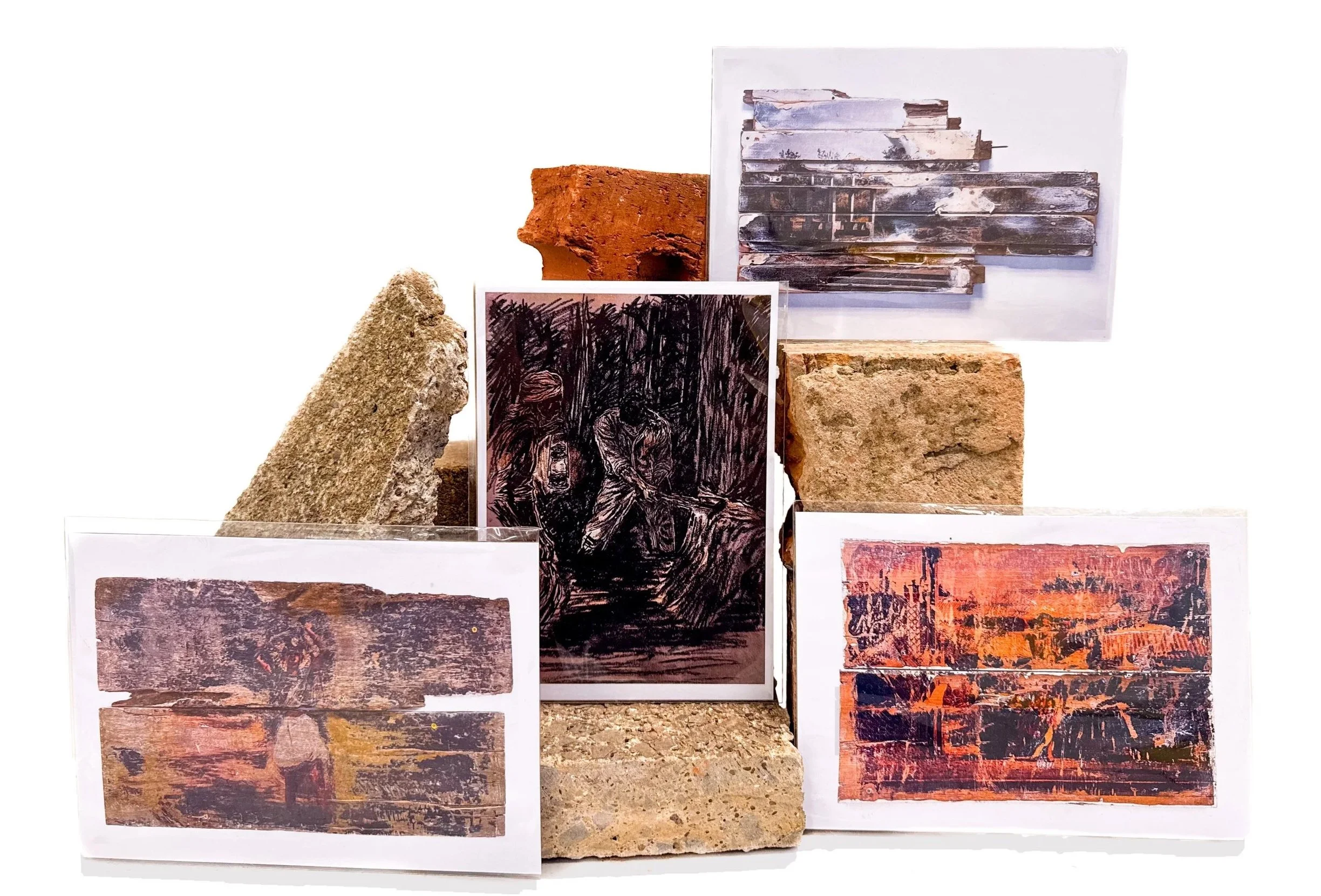 Various art prints leaning against bricks of various sizes and colours