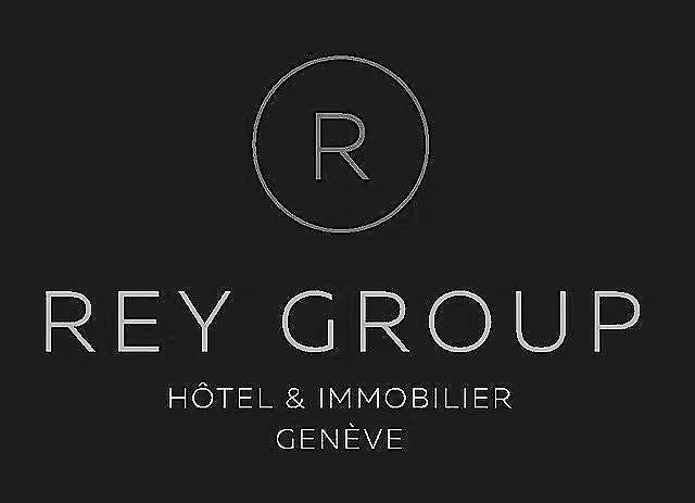 Logo du groupe Rey, hôtel et immobilier à Genève, sur un fond noir.