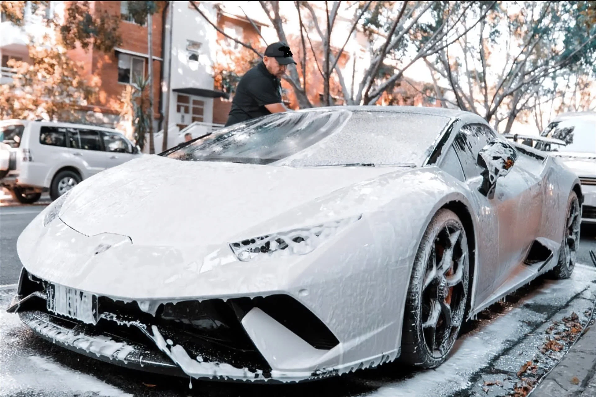 Dan Diaz, owner of Dan the Detailer, meticulously detailing a white Lamborghini, exemplifying premium mobile car detailing on the Gold Coast