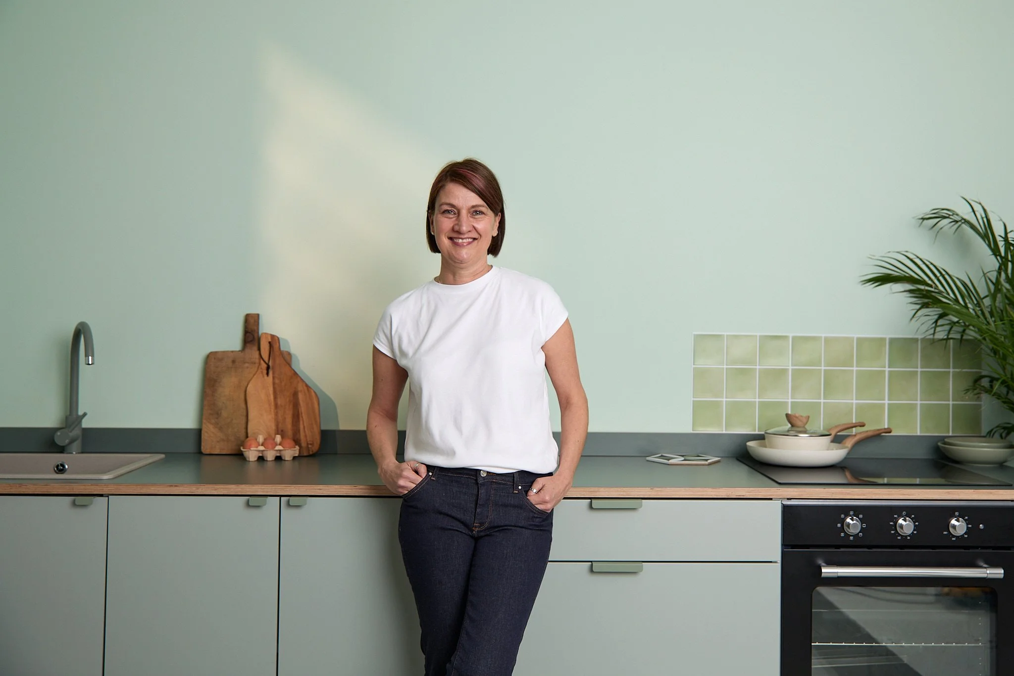 Caroline standing in a kitchen, relaxed.