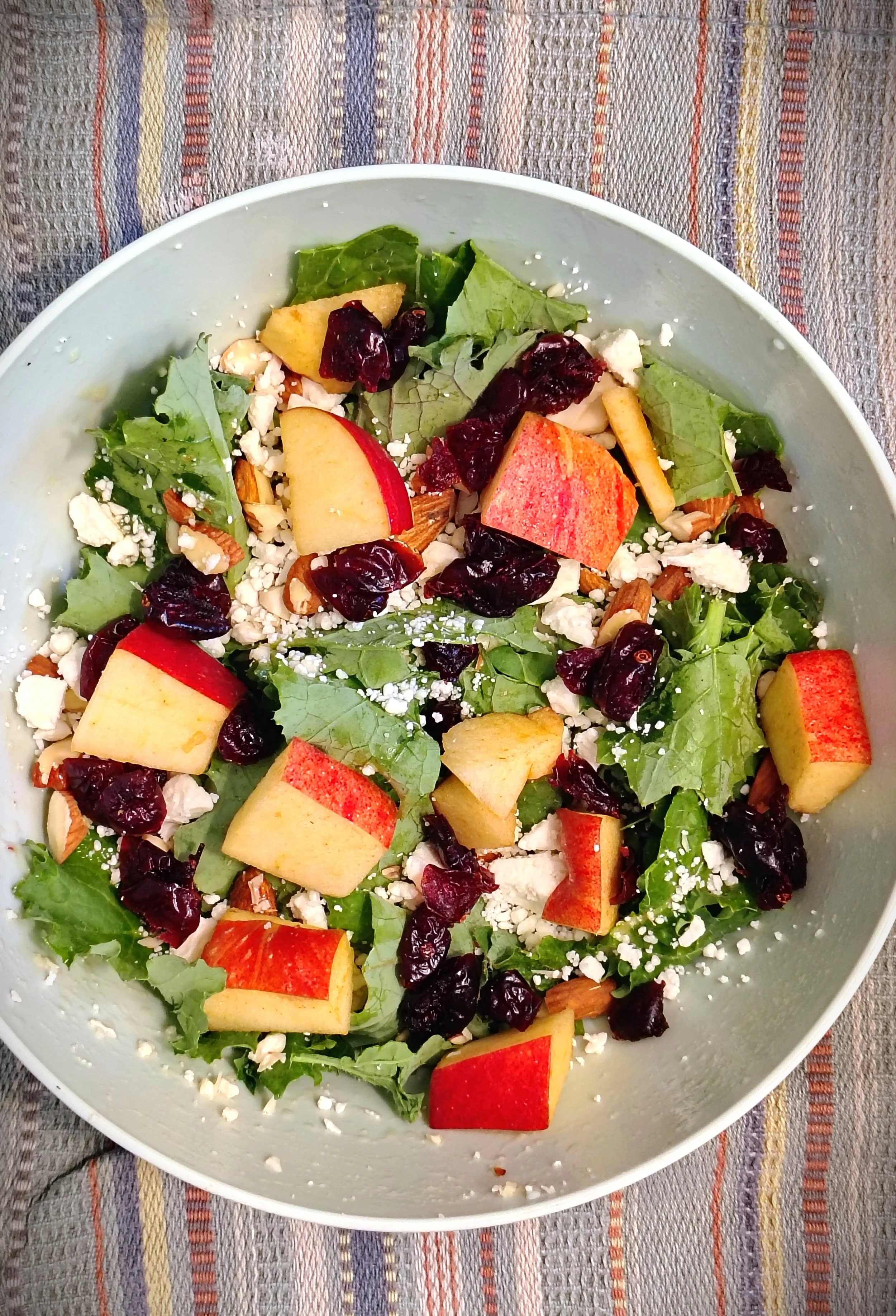 Healthy kale salad with apples, nuts, and craisins