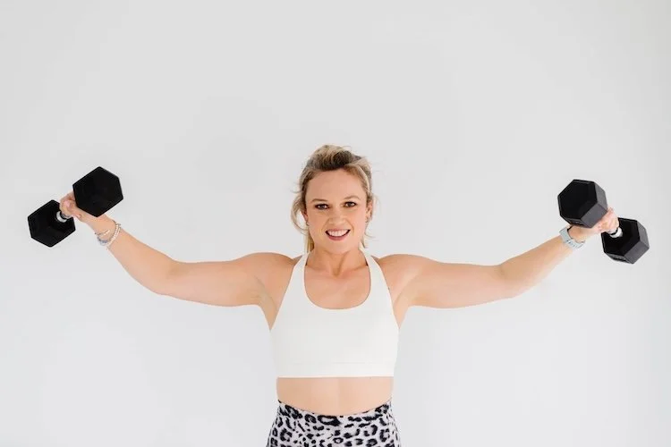 Georgy Dillon in white vest lifting dumbbells