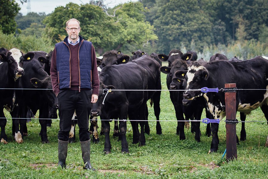 Steve infront of Electric Fence with Cattle behind