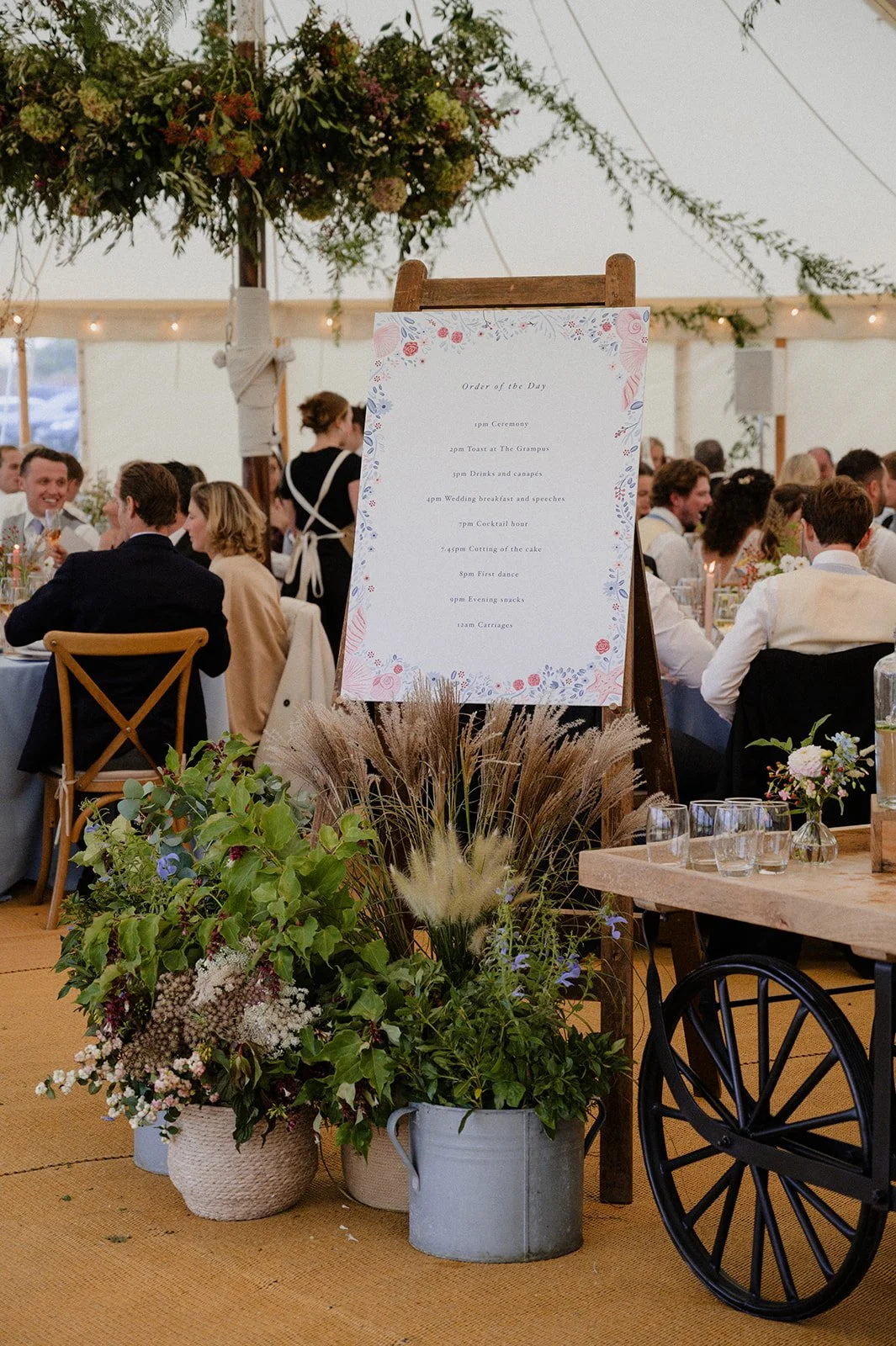 table plan sign surrounded by seasonal British flowers in Devon marquee