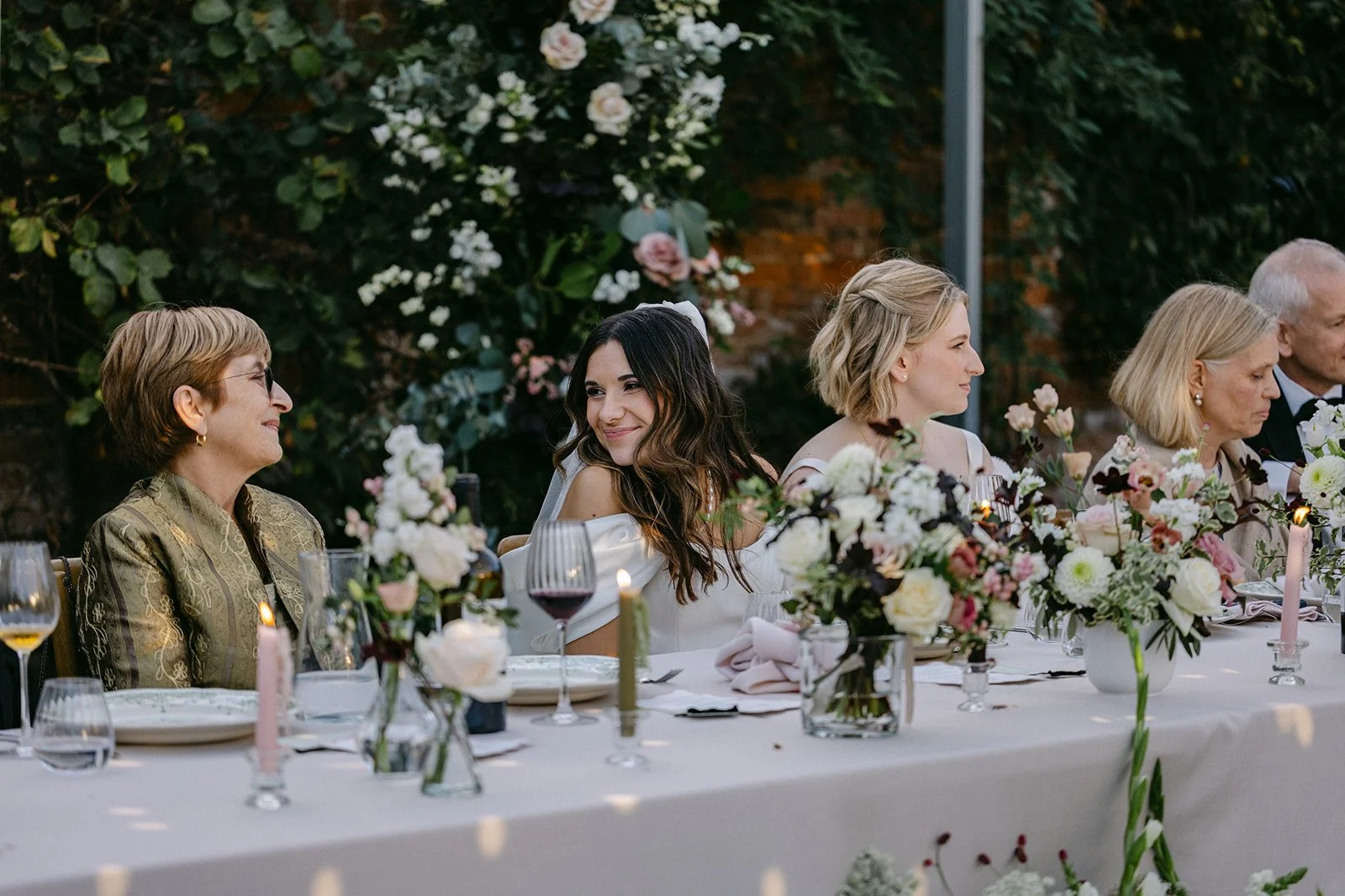 brides at top table at Kingston Estate wedding breakfast surrounded by ivory, blush and deep chocolate low table vases and bud vases