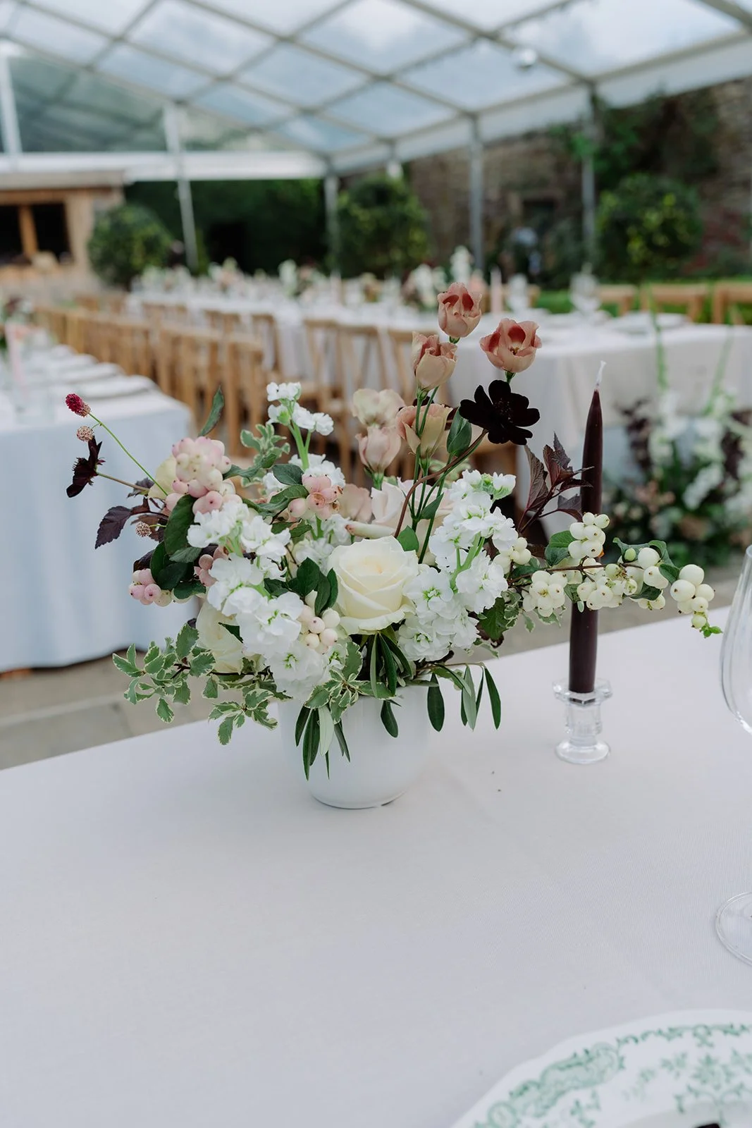 ivory, mocha and burgundy seasonal flower arrangements in low ceramic bowls for a wedding breakfast at Kingston Estate