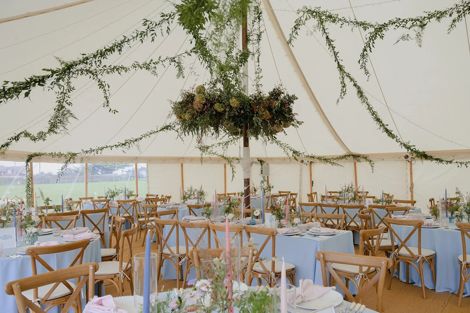 stylish high end marquee with flower chandeliers, trailing foliage garlands and delicate bud vases in Croyde marquee
