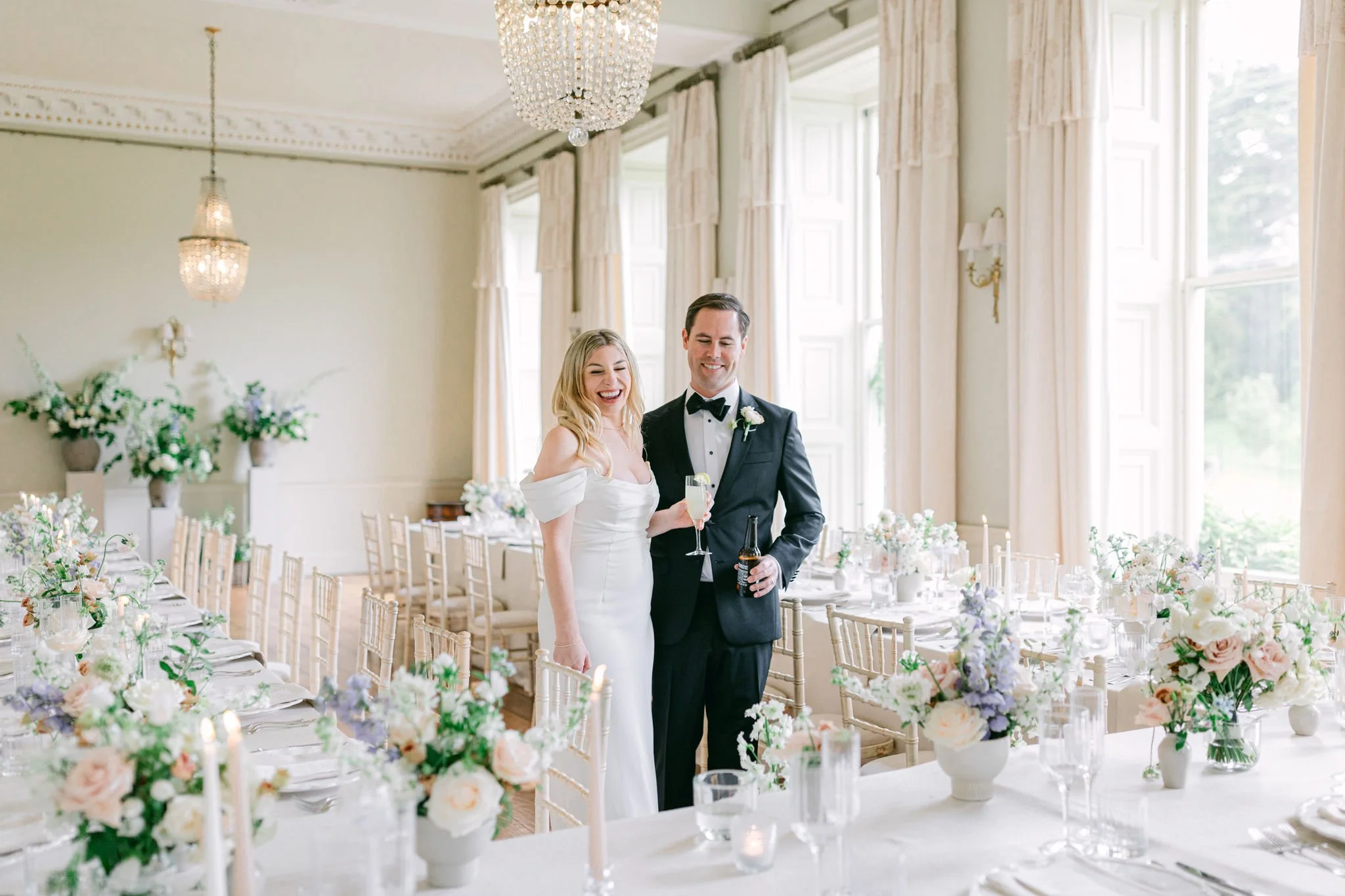 Happy couple looking at table flowers at Pynes House dining room